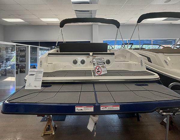 2024 Bayliner DX 2050 boat displayed indoors, rear view with swim platform.