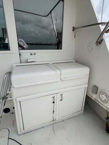 1985 Hatteras 45 Convertible yacht deck with storage cabinet and window view.