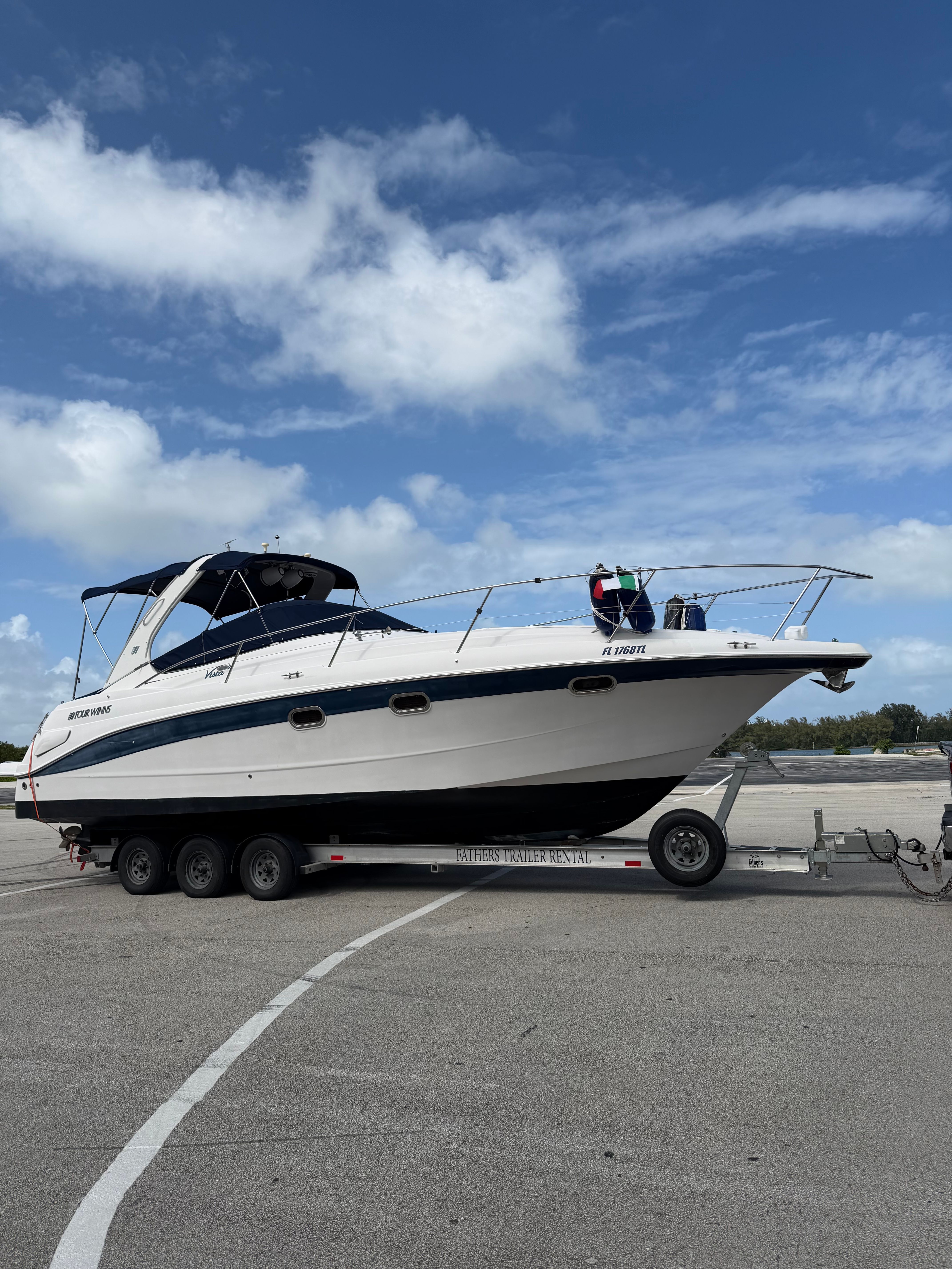 2006 Four Winns 328 Vista boat on trailer under blue sky.