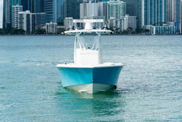2019 Contender 32 ST boat on water with city skyline backdrop.