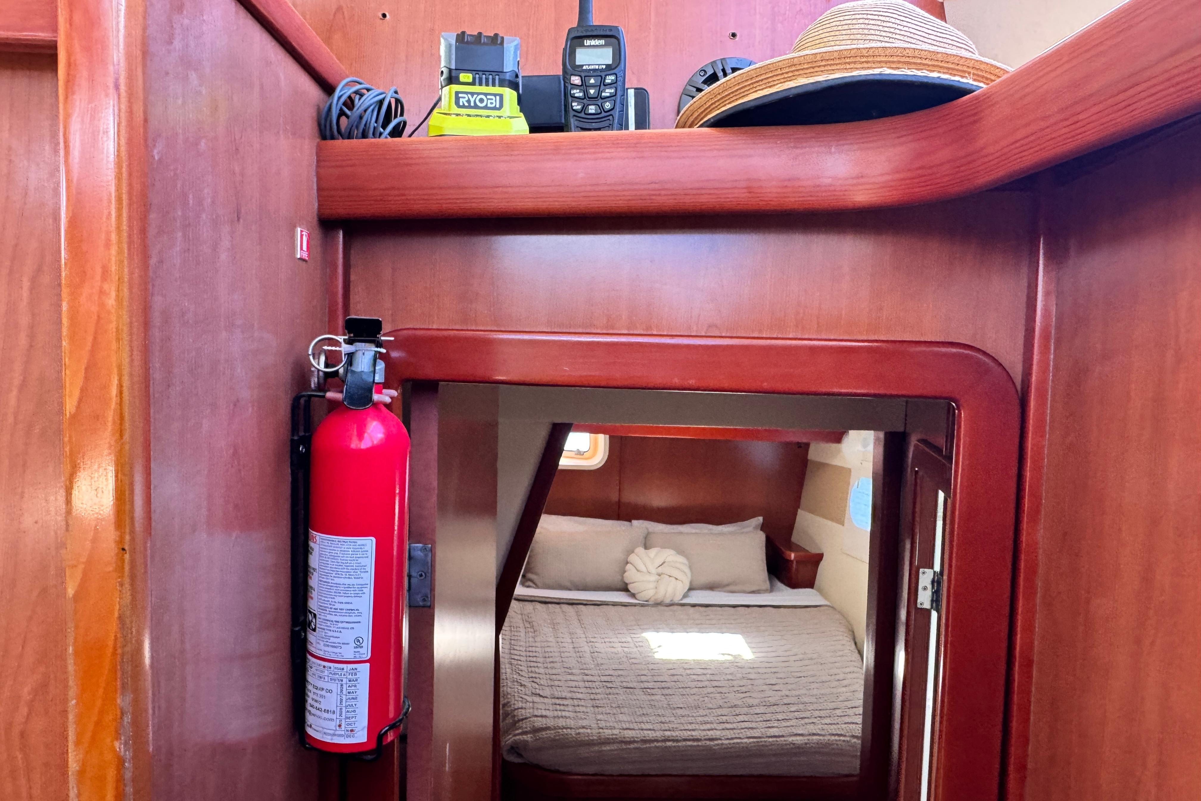 Interior of a 2011 Leopard 46 yacht cabin with bed, fire extinguisher, and equipment.