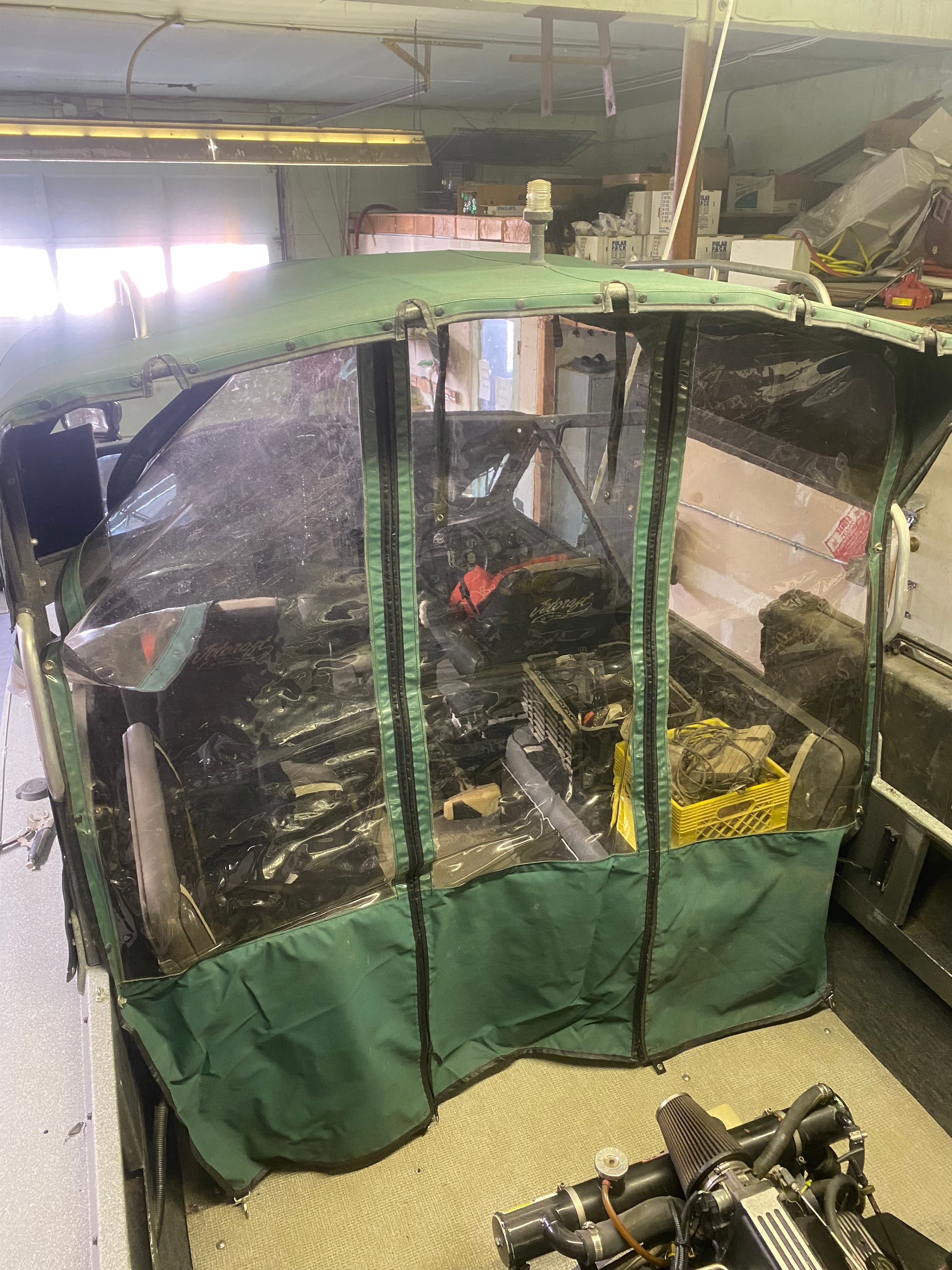 1993 Jetcraft Fastwater boat with green canopy in garage.
