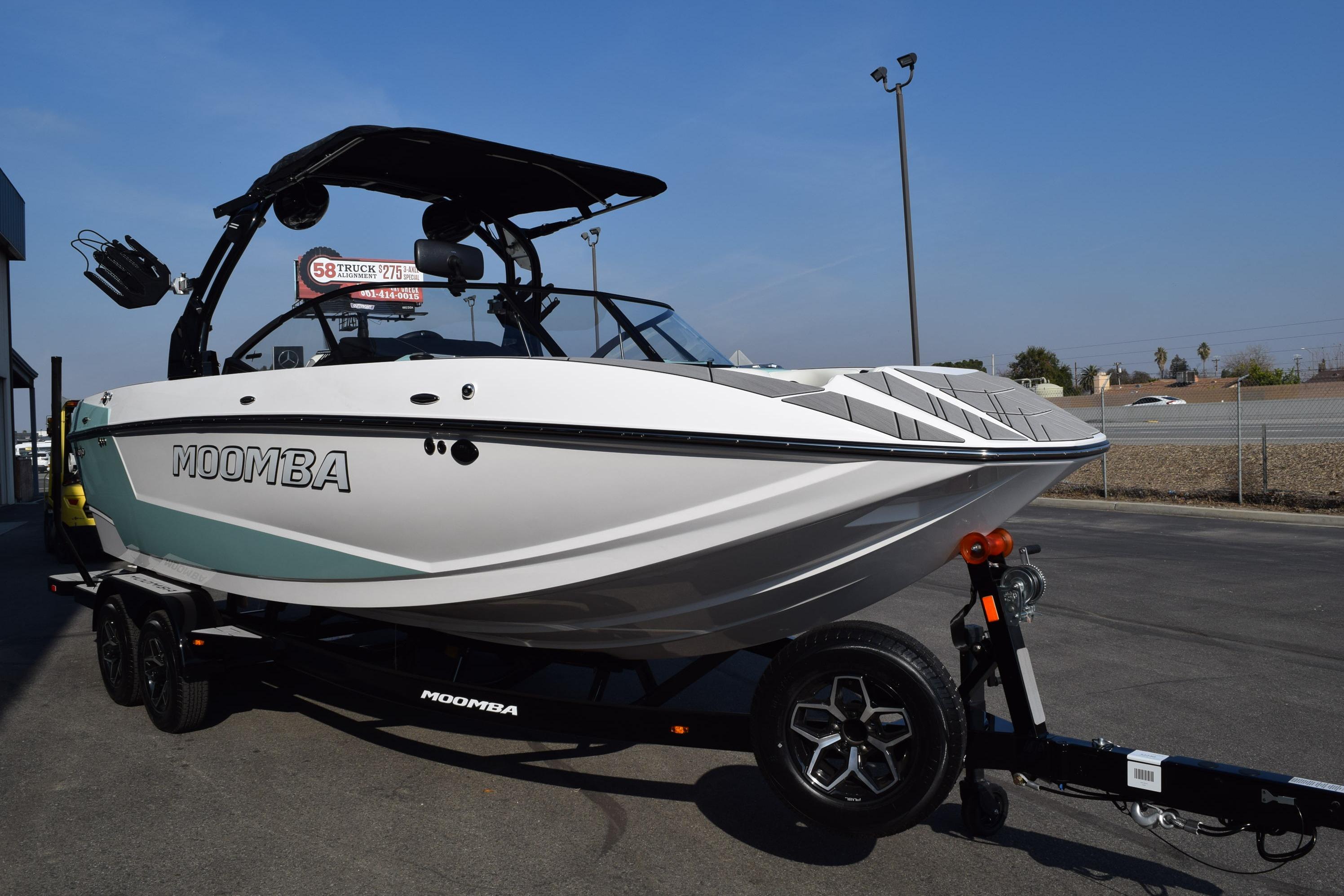 2025 Moomba Mojo boat on trailer, sleek design, parked outdoors.
