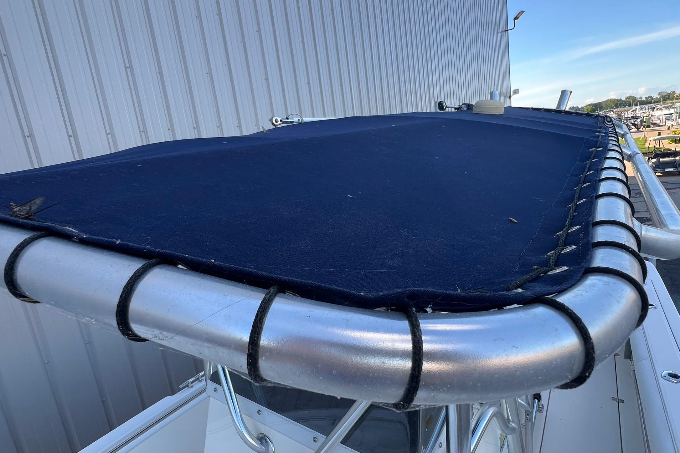 2006 Edgewater 245CC boat with blue canvas cover and metal frame.