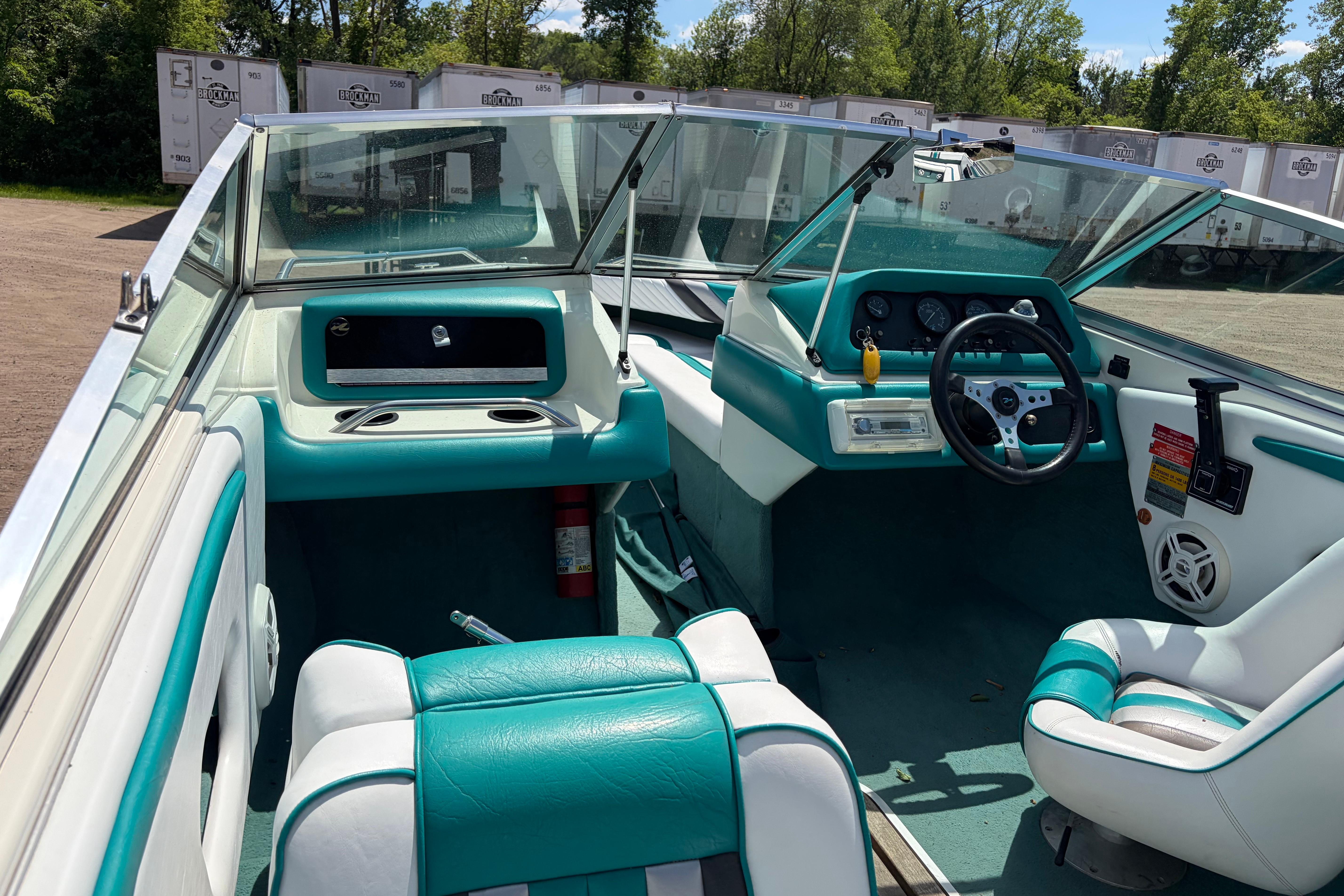 Interior of a 1990 Sea Ray 180 Bow Rider boat with teal and white seating.