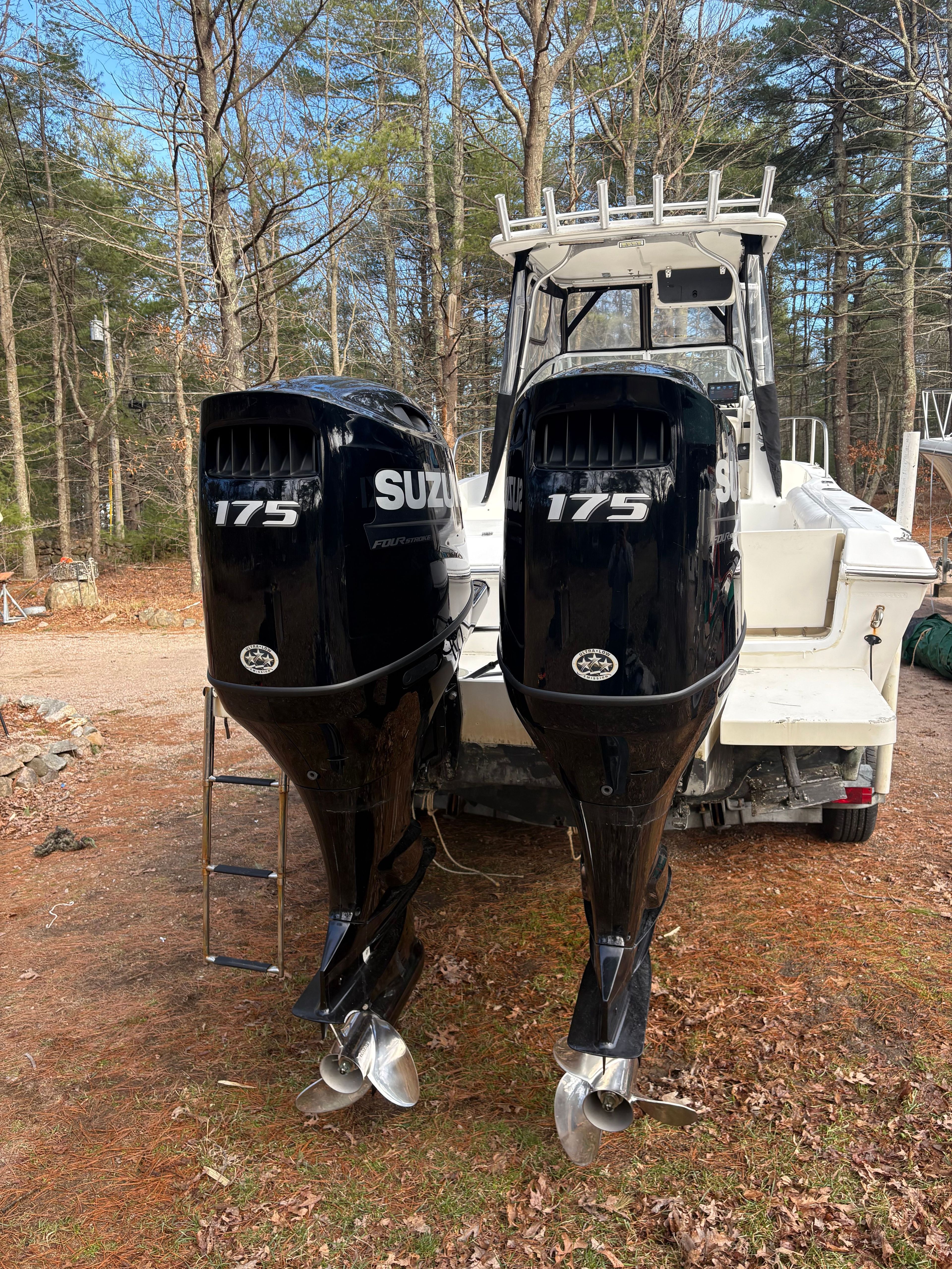 Spacecraft Cuddy 2000 with Suzuki 175 HP outboard motors in a forest setting.