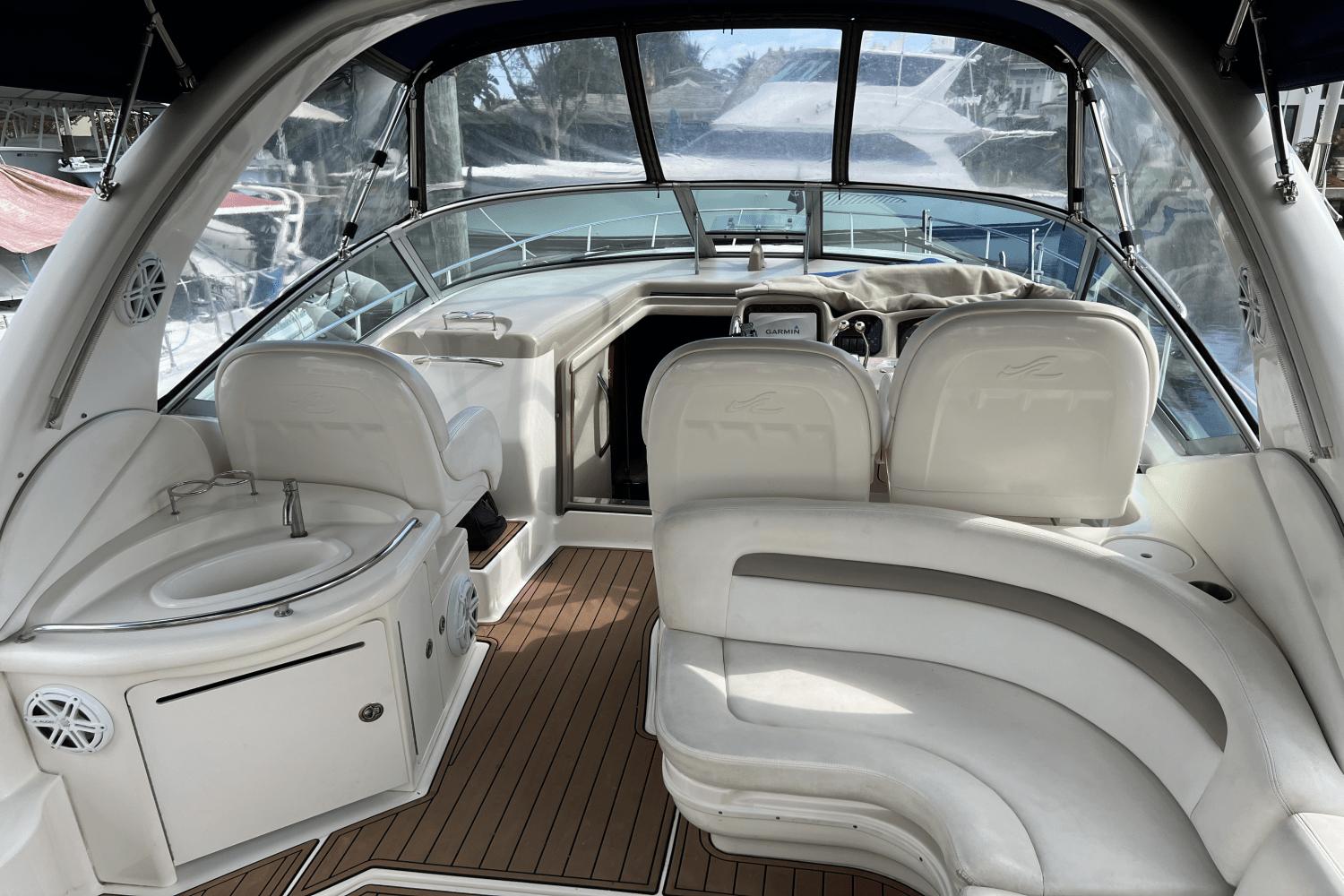 2005 Sea Ray 340 Sundancer interior with white seating and wood flooring.