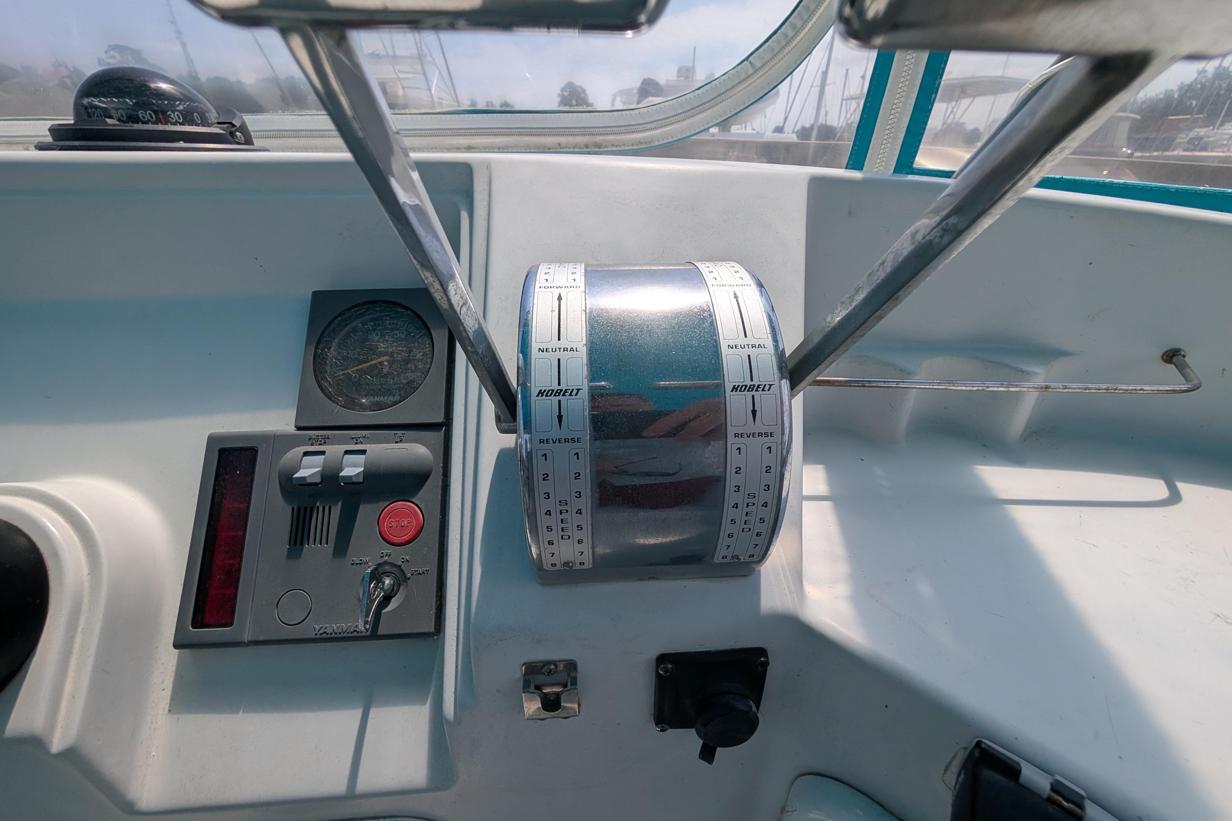 Control panel of a 2004 PDQ 34 Powercat boat with throttle and navigation instruments.