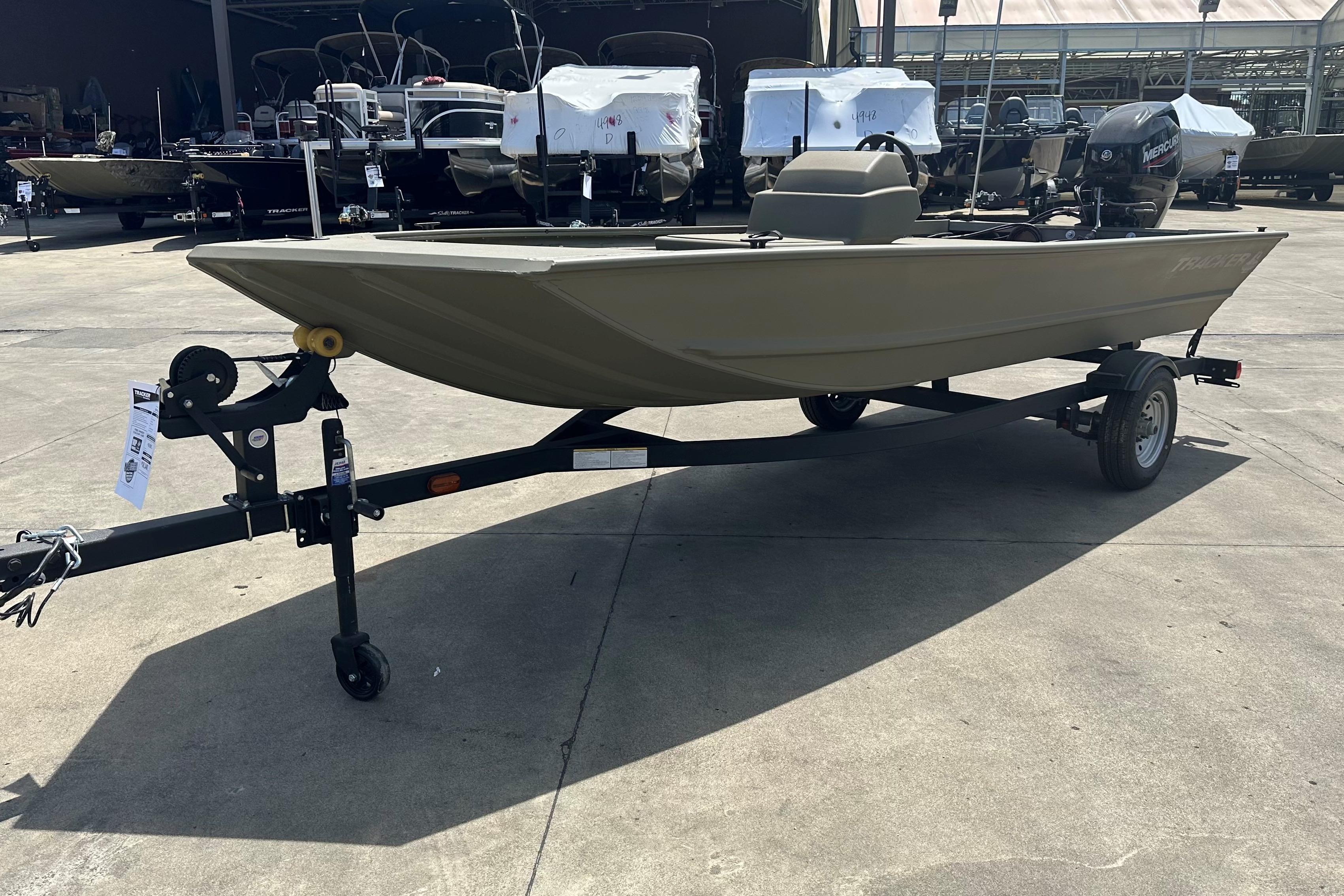 2026 Tracker Grizzly 1648 SC boat on trailer in outdoor showroom.