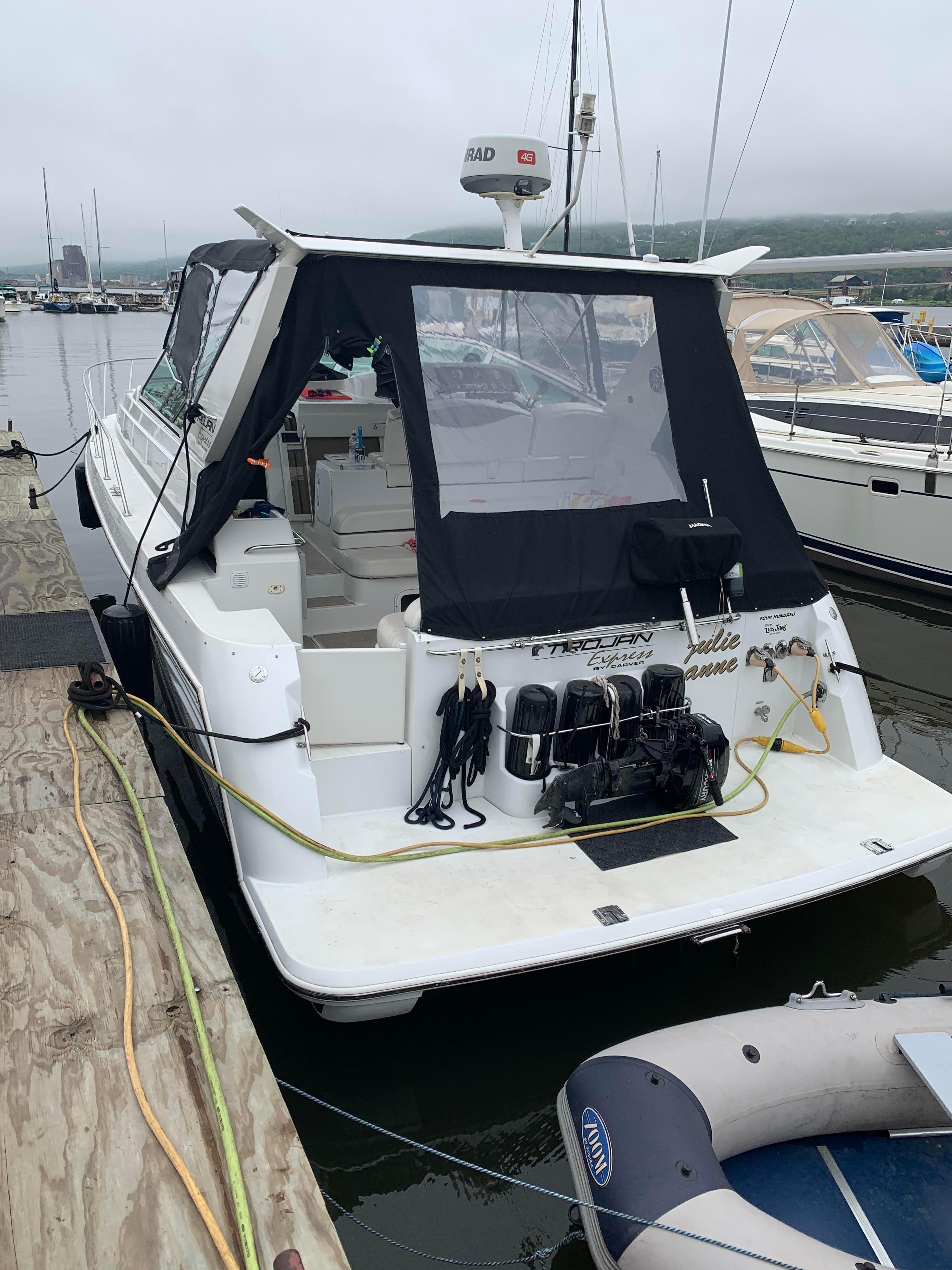 2000 Trojan 400 Express Yacht docked at marina, rear view with black canopy.