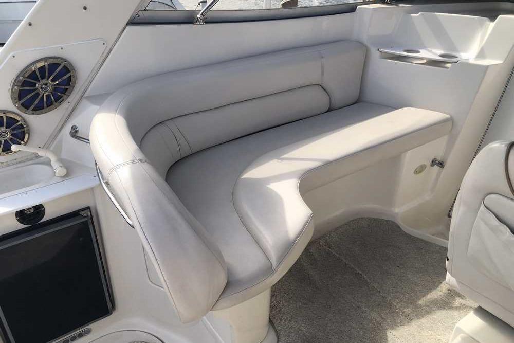 Interior of a 1999 Regal Commodore 2760 boat with plush seating and built-in speakers.