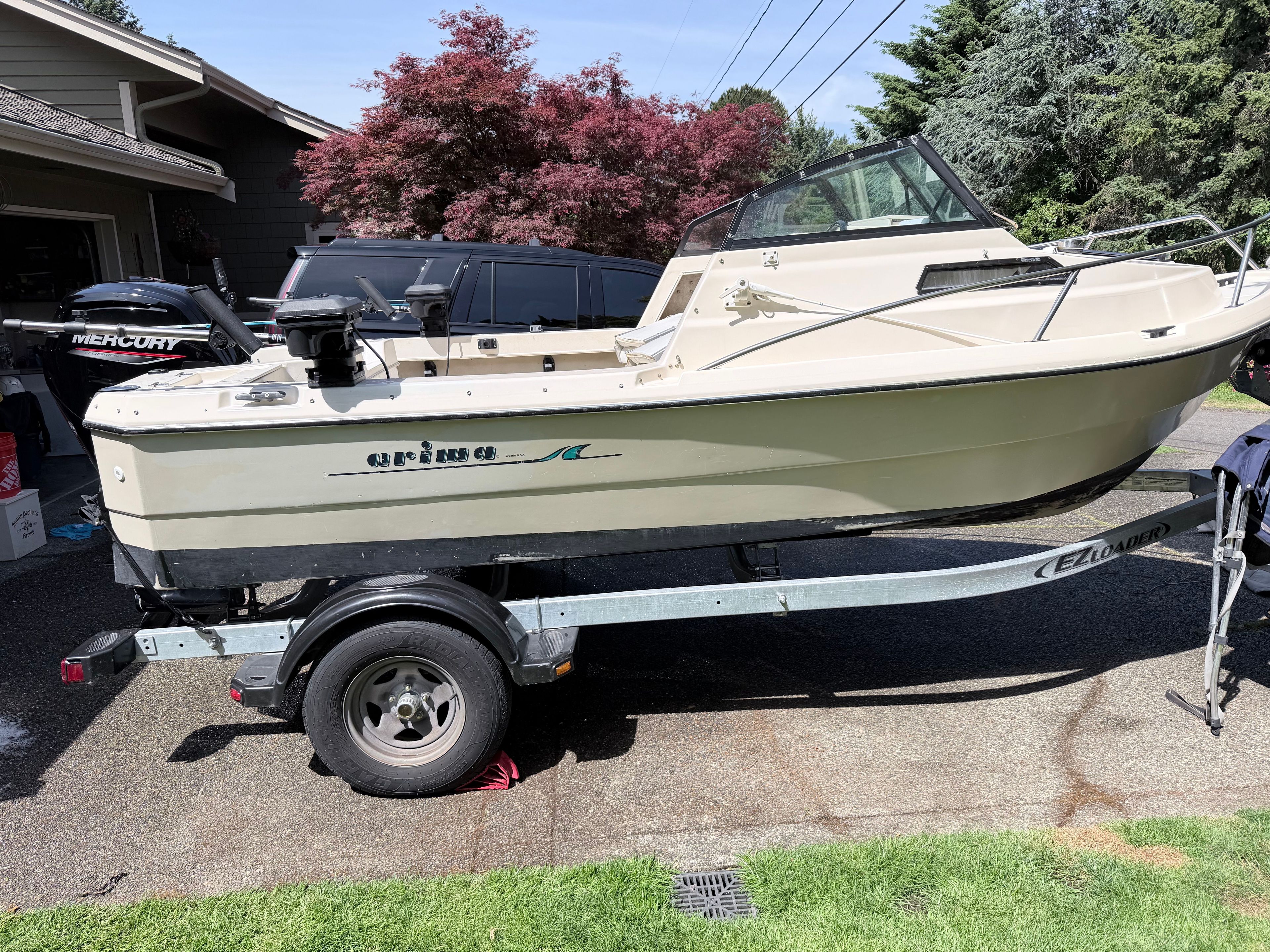 A 1993 Arima Sea Explorer 1511 on a trailer in a driveway.