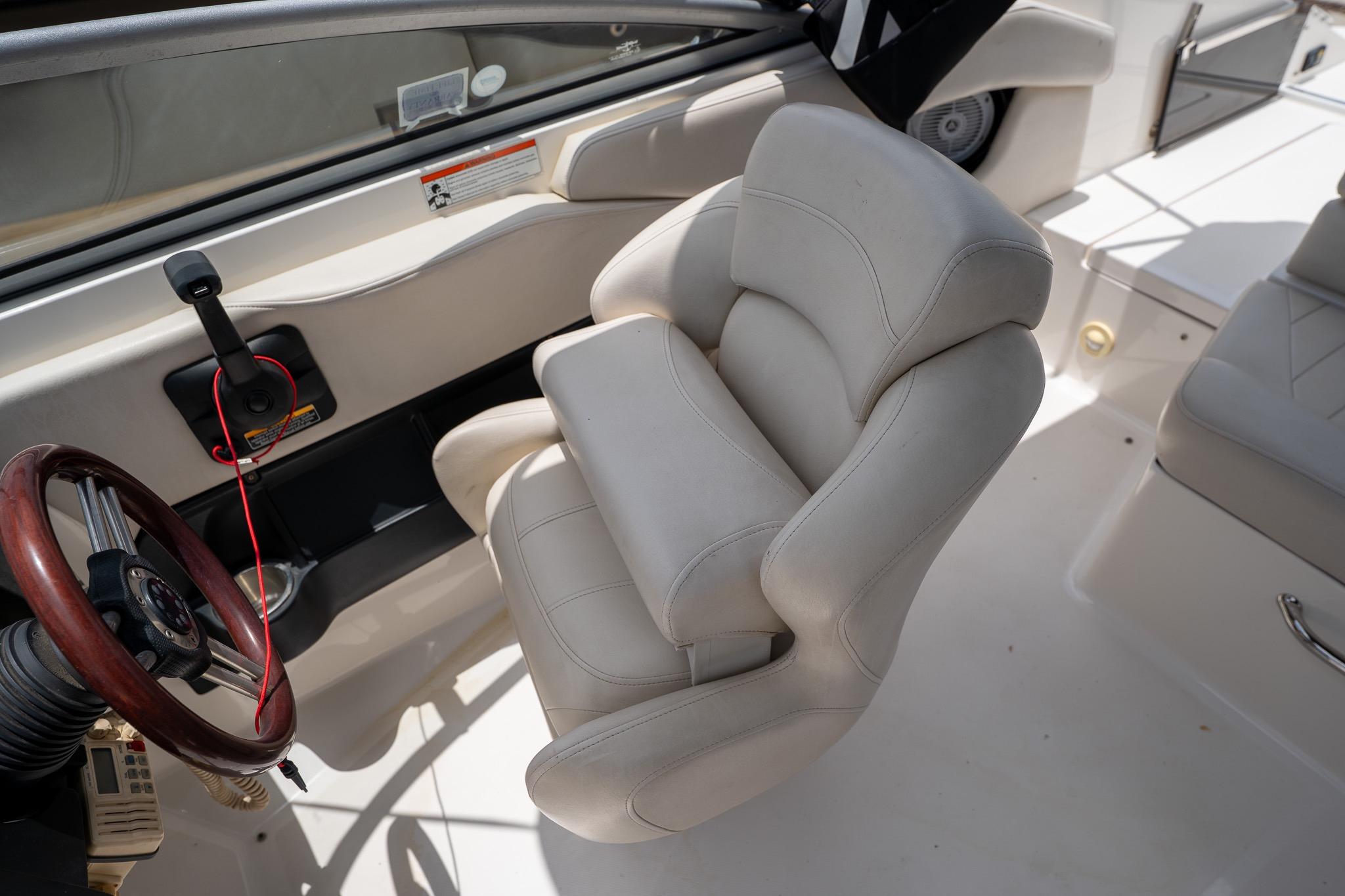 Interior of a 2008 Regal 2000 Bowrider boat, featuring a plush captain's chair and steering wheel.