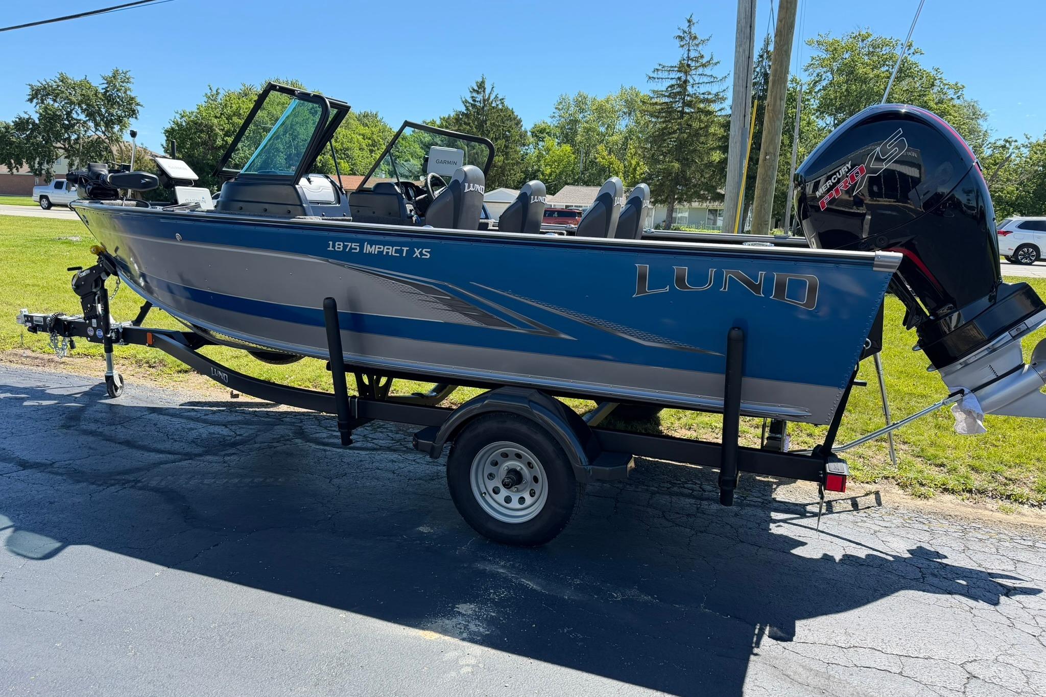2024 Lund 1875 Impact XS Sport boat on trailer, parked outdoors.