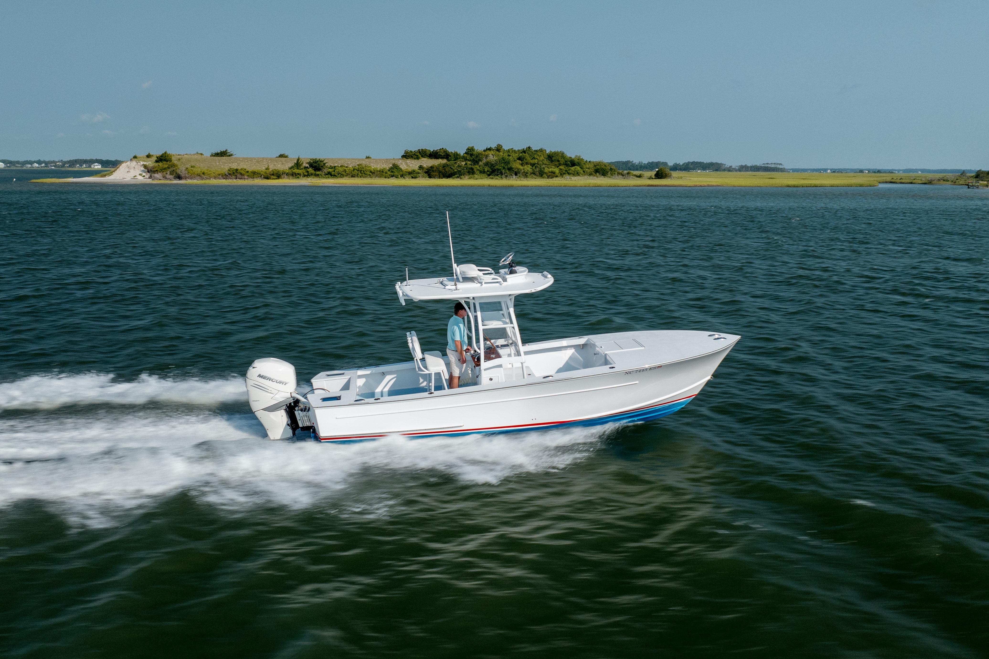 2019 Gamefisherman 26 Cuddy Cabin cruising on open water near a small island.