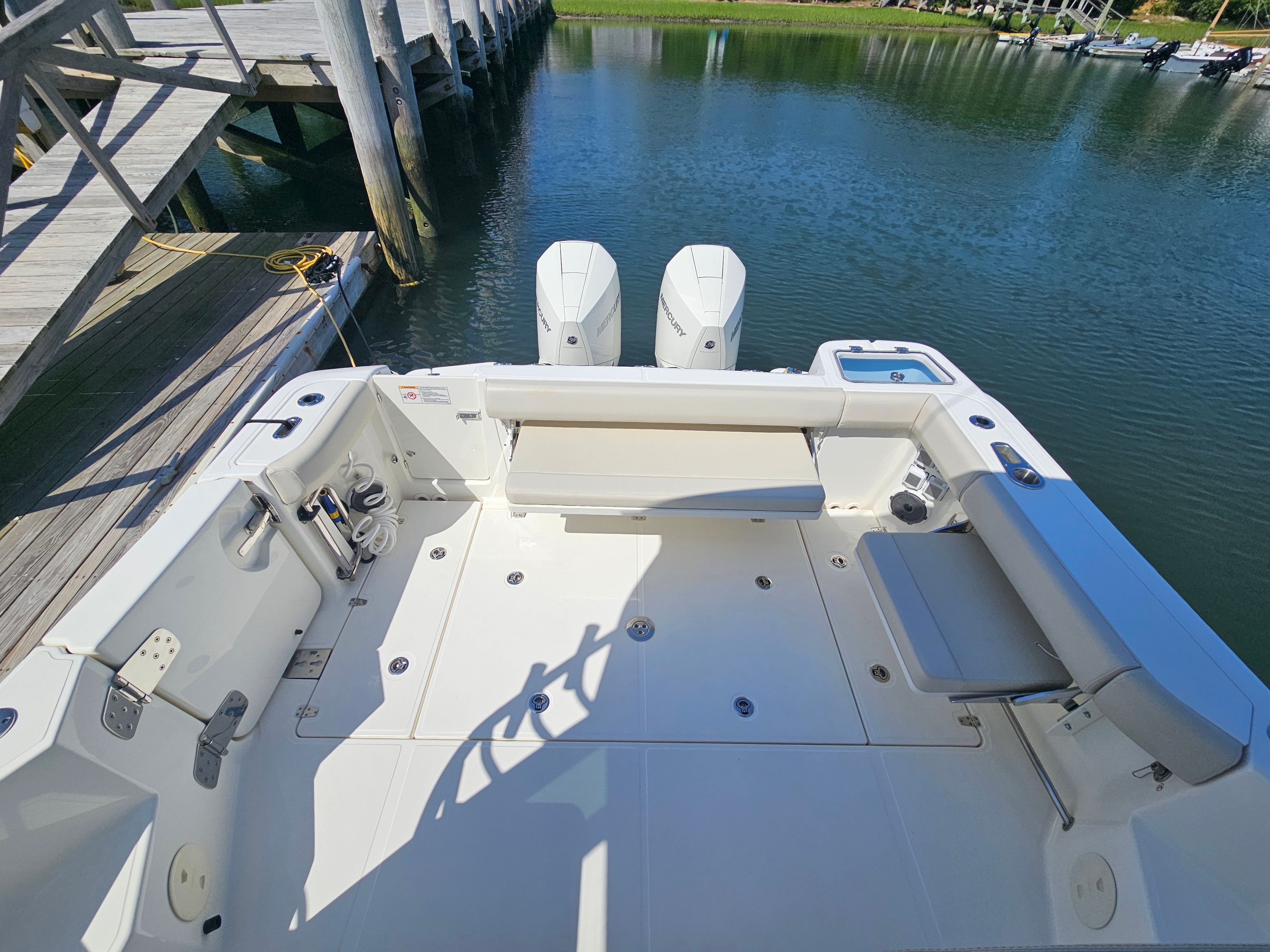 The image shows the stern of a 2023 Boston Whaler 325 Conquest boat docked.