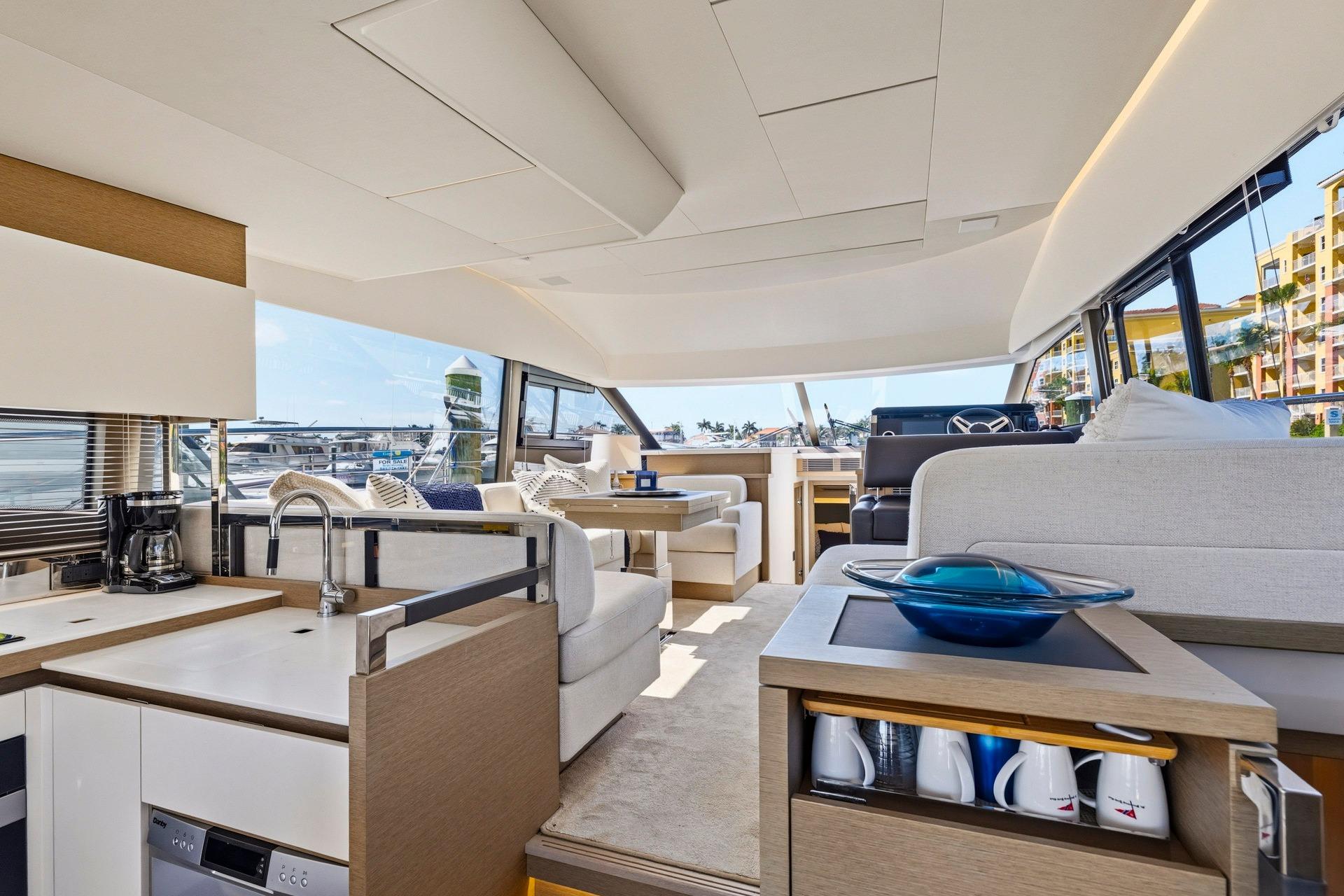 Luxurious interior of 2022 Prestige 520 yacht with modern kitchen and seating area.