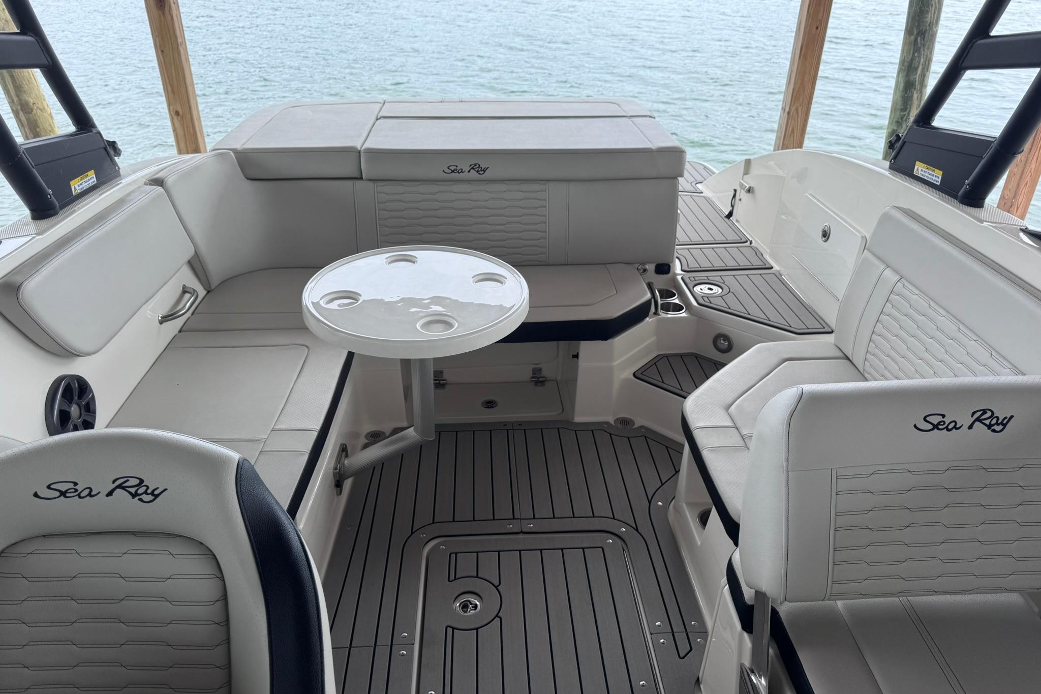 2021 Sea Ray SPX 230 boat interior with seating and table, overlooking water.