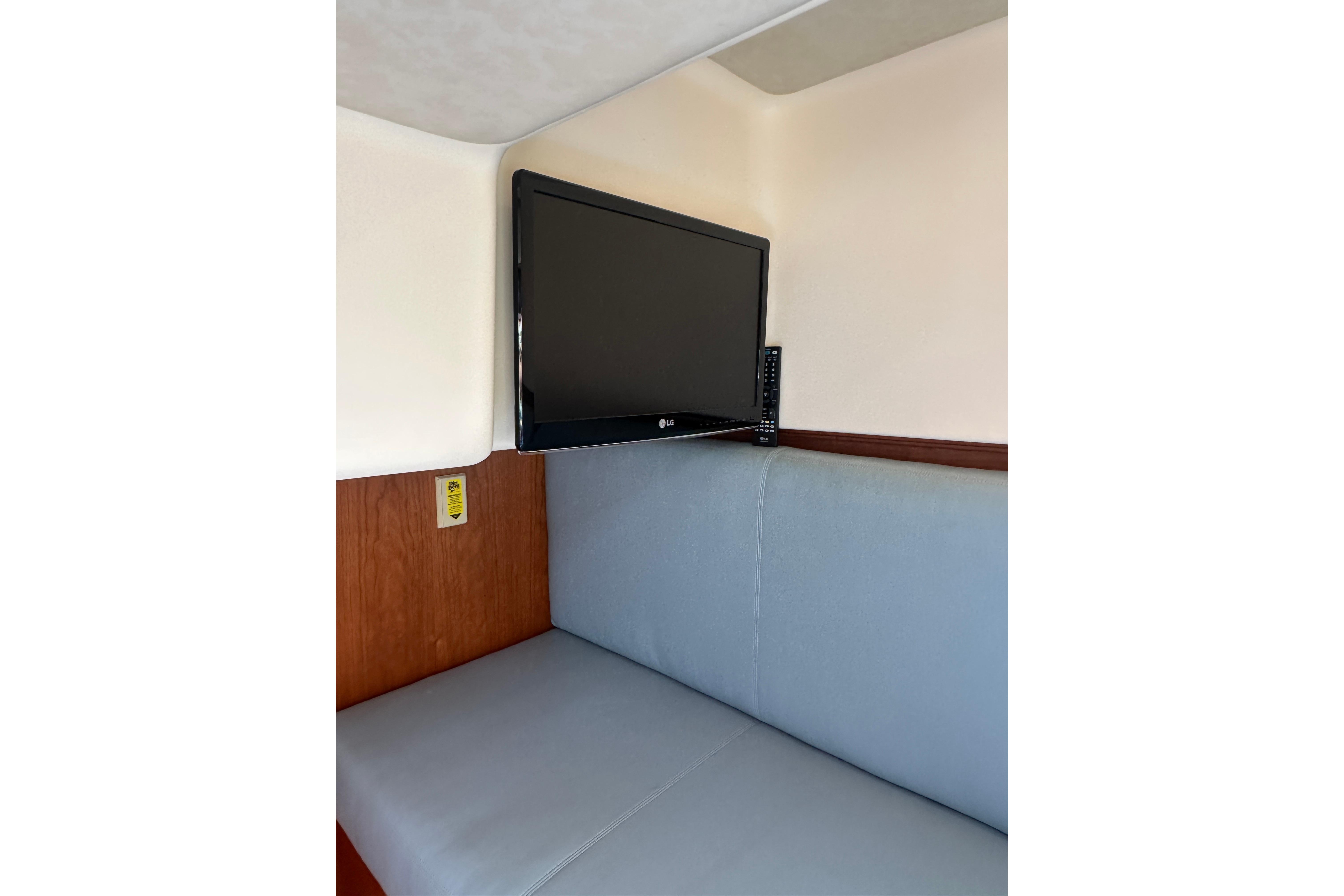 Interior of 2013 Sabre 38 Salon Express with mounted TV and cushioned seating.