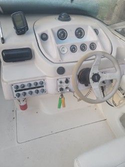 Dashboard of a 1996 Wellcraft 2400S boat with steering wheel and gauges.