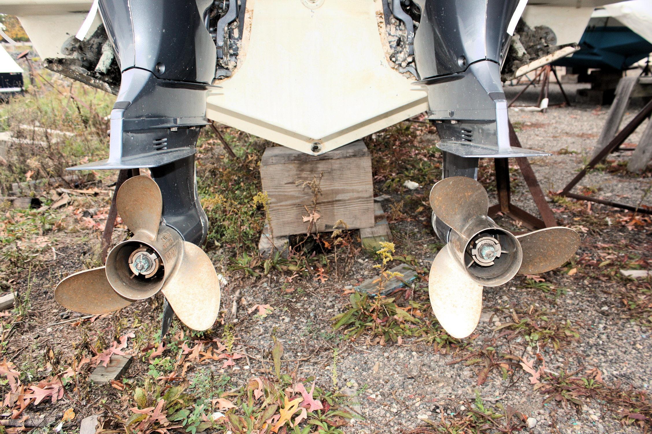 Twin propellers of a 2013 Pursuit ST 310 Sport boat on dry land.