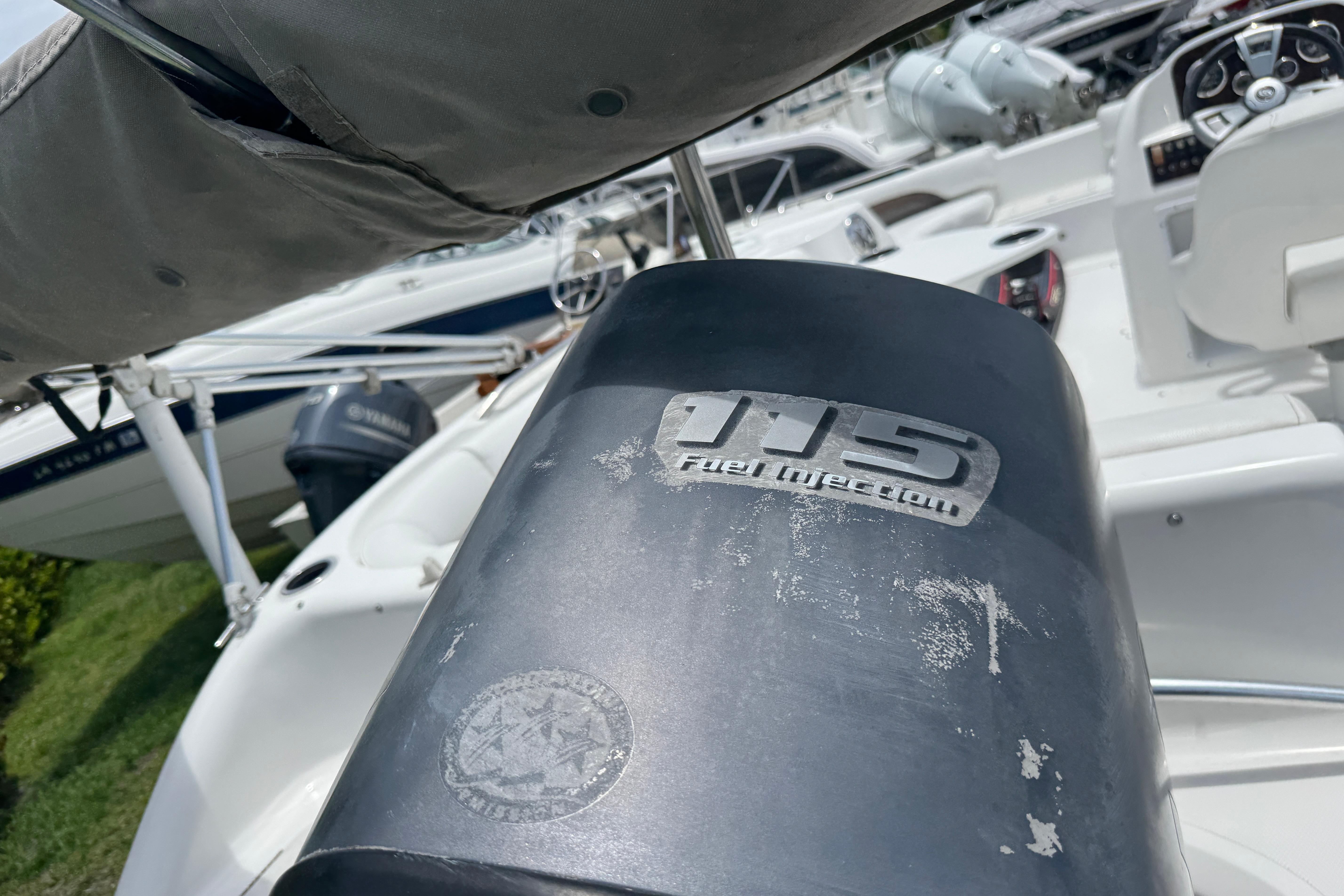 2013 Hurricane SunDeck Sport 188 OB with 115 fuel injection engine, docked among boats.