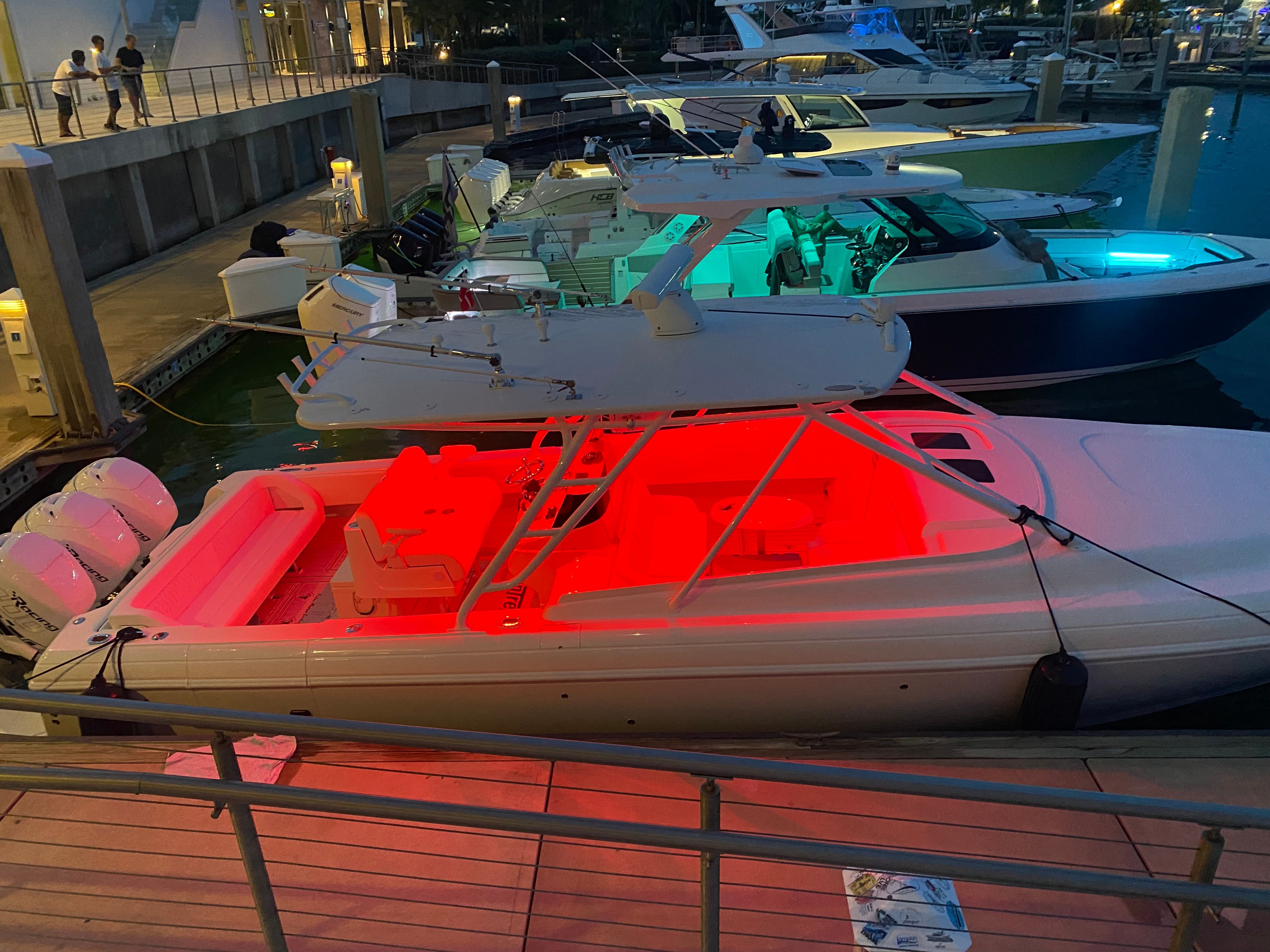A 2011 Intrepid 37 boat docked, illuminated by red lights.