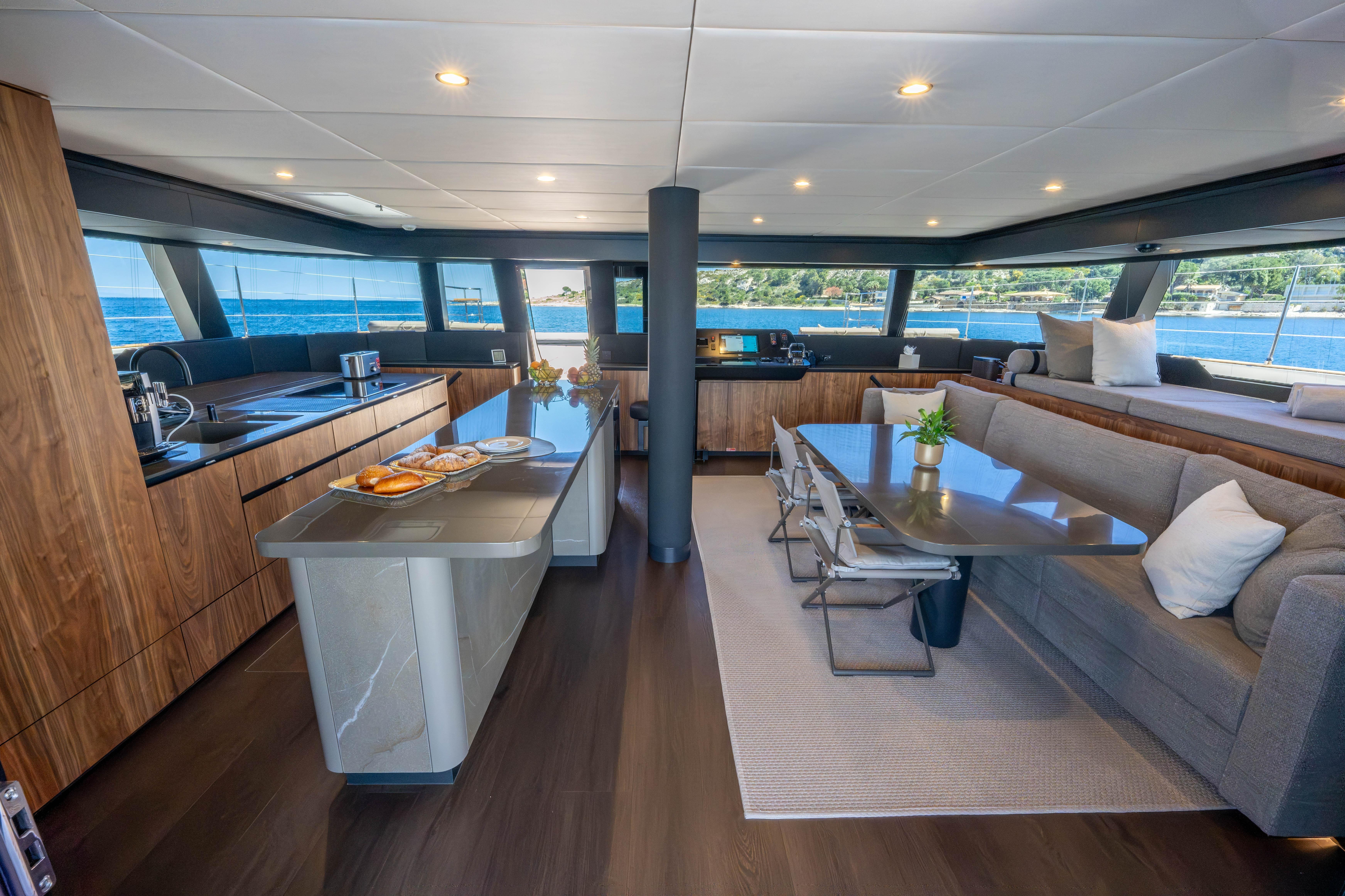 Luxurious interior of 2025 Sunreef 60 yacht with modern kitchen and dining area.
