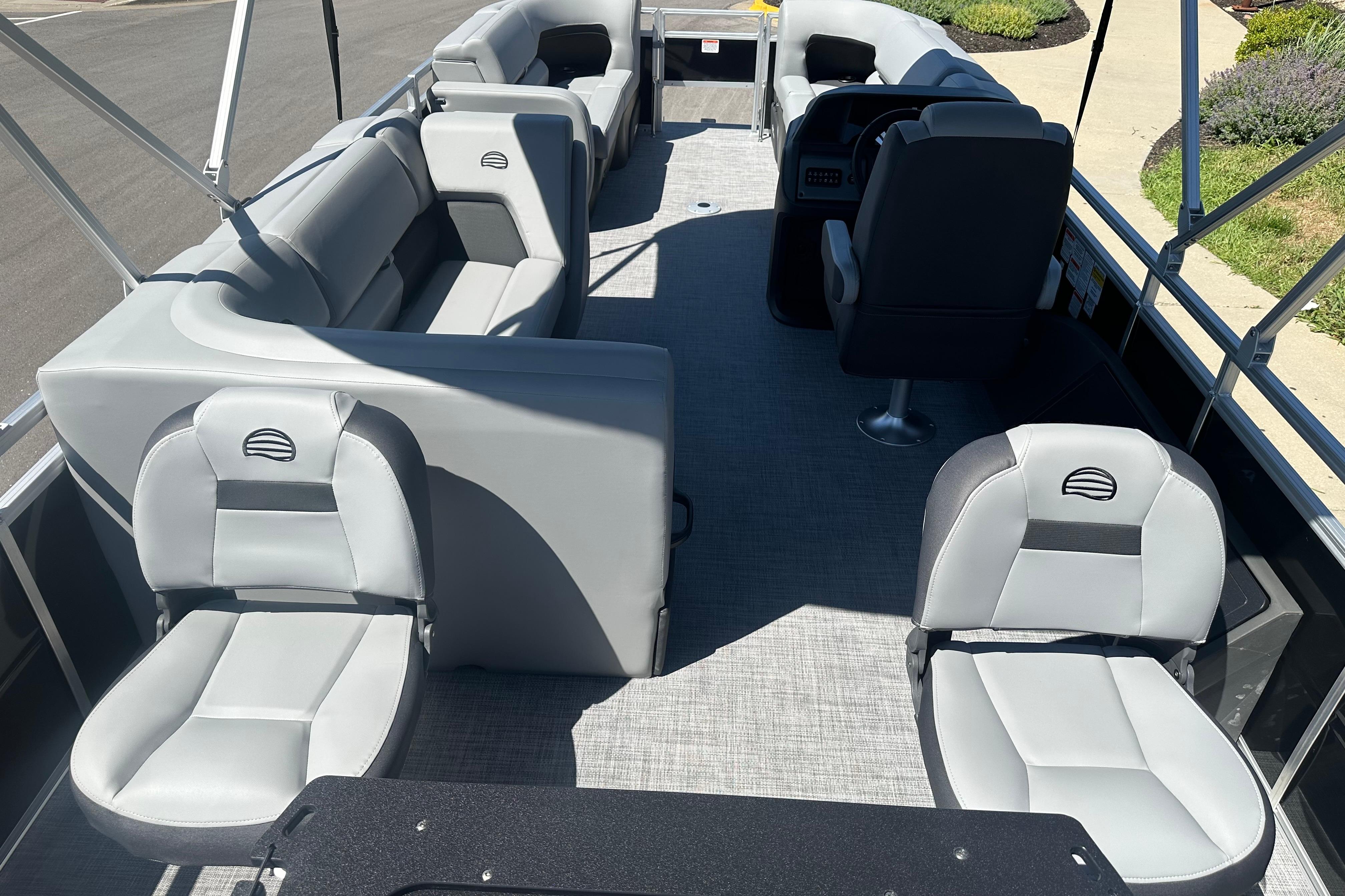 2026 Sun Tracker SportFish 22 DLX pontoon boat interior with gray seating and helm.