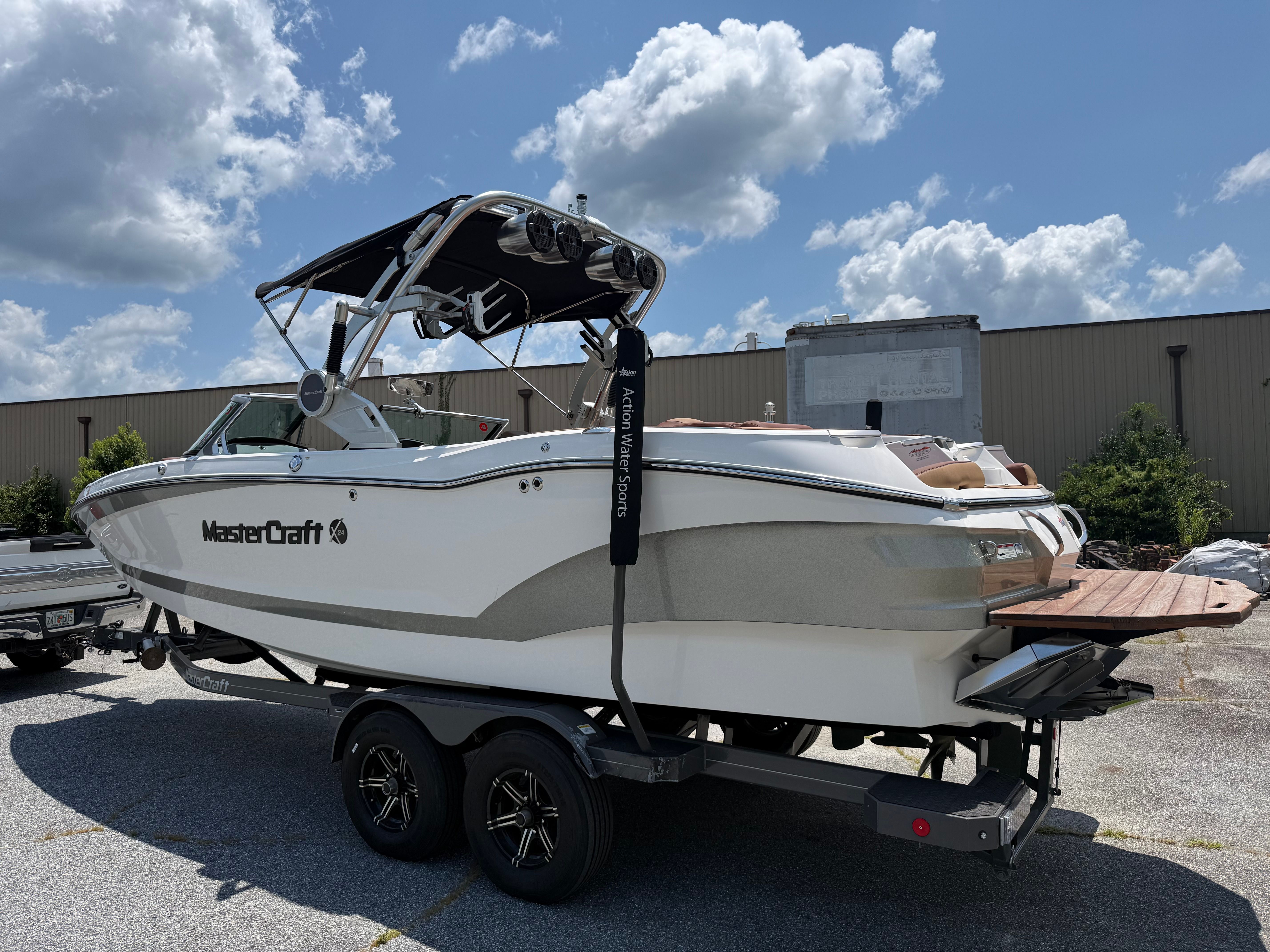 A 2021 MasterCraft X24 boat on a trailer under a cloudy sky.