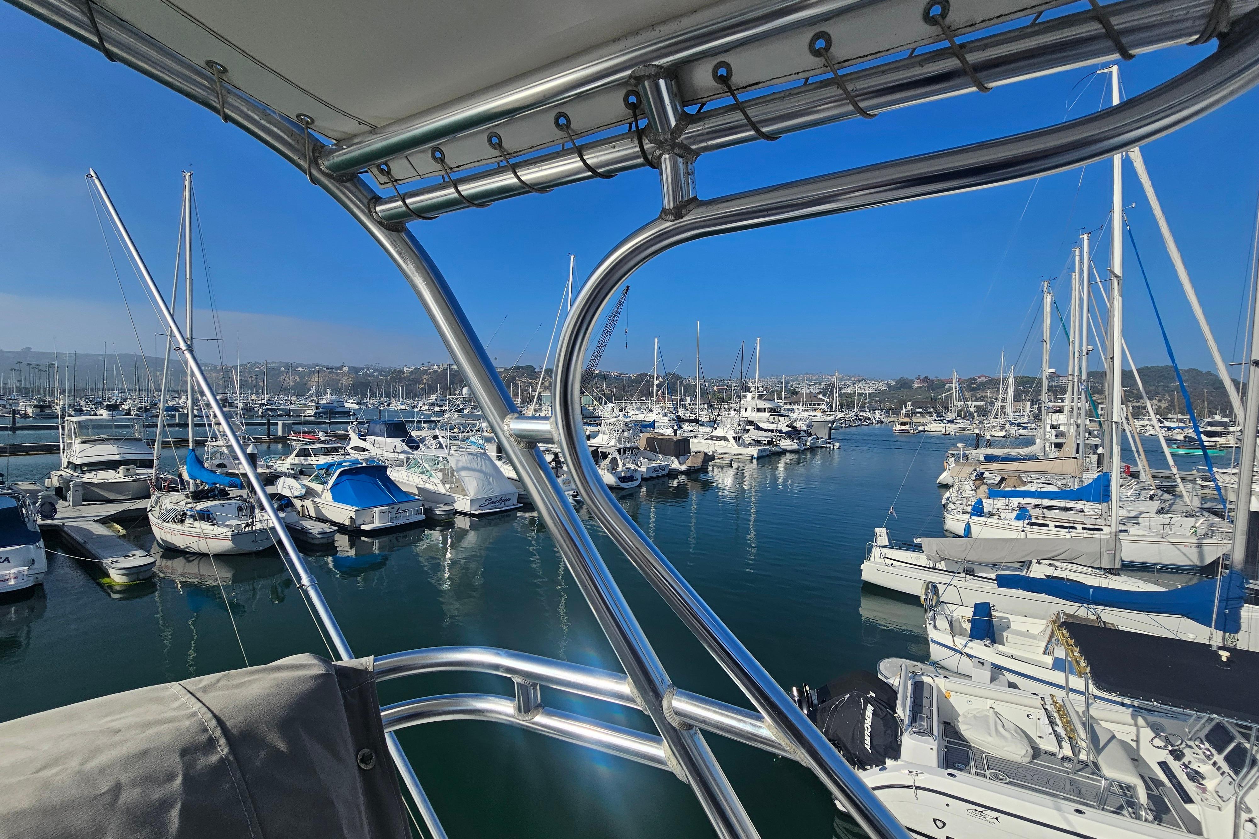 Marina view from a 2003 Topaz 32 Express boat, showcasing docked yachts and clear blue skies.