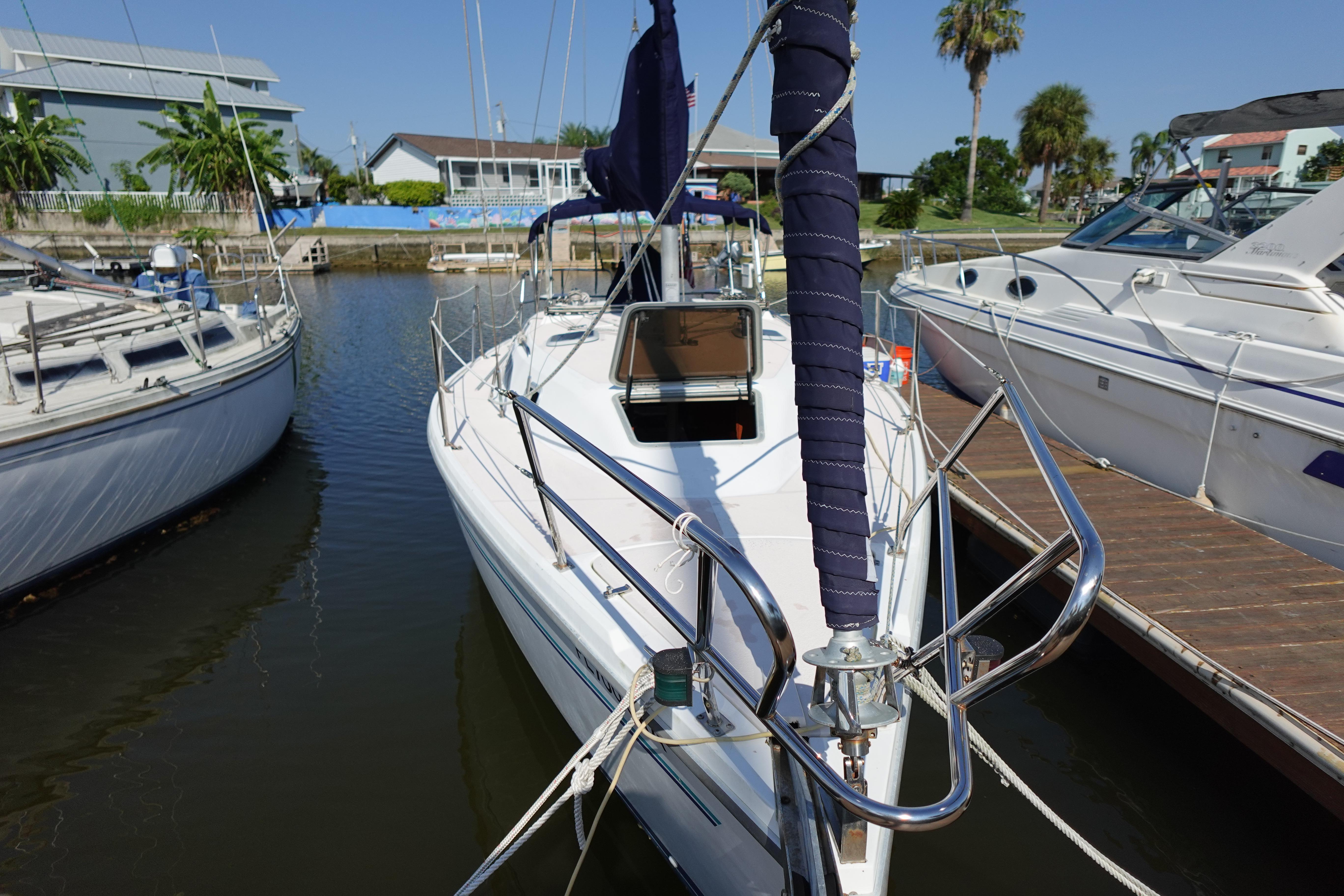1997 Catalina 28 sailboat docked in a marina, surrounded by other boats.