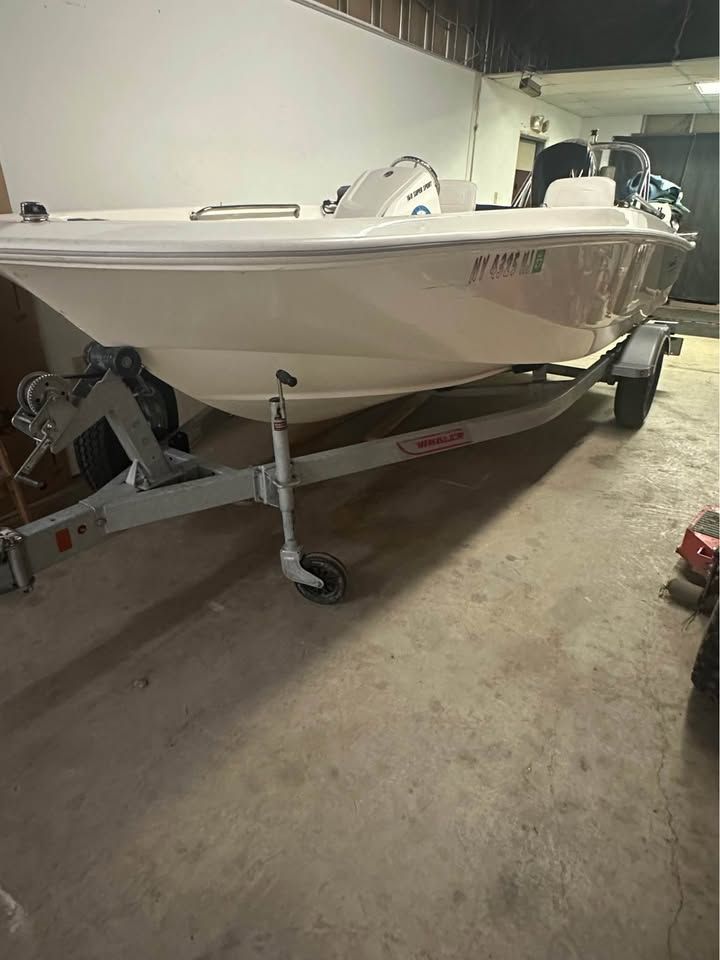 A 2020 Boston Whaler 160 on a trailer in a garage.