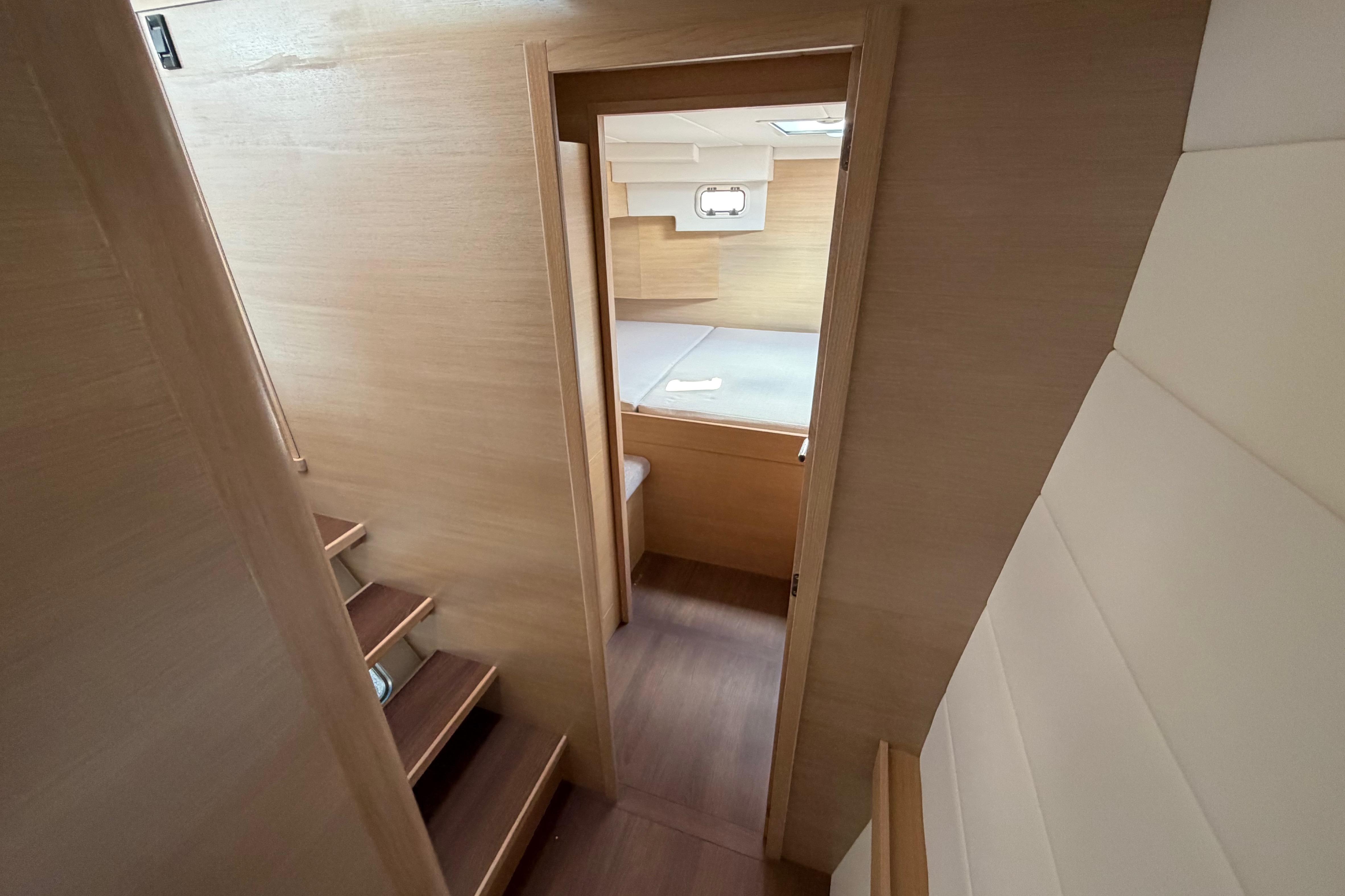 Interior view of 2025 C-Catamarans 48, featuring wooden stairs and cozy cabin.