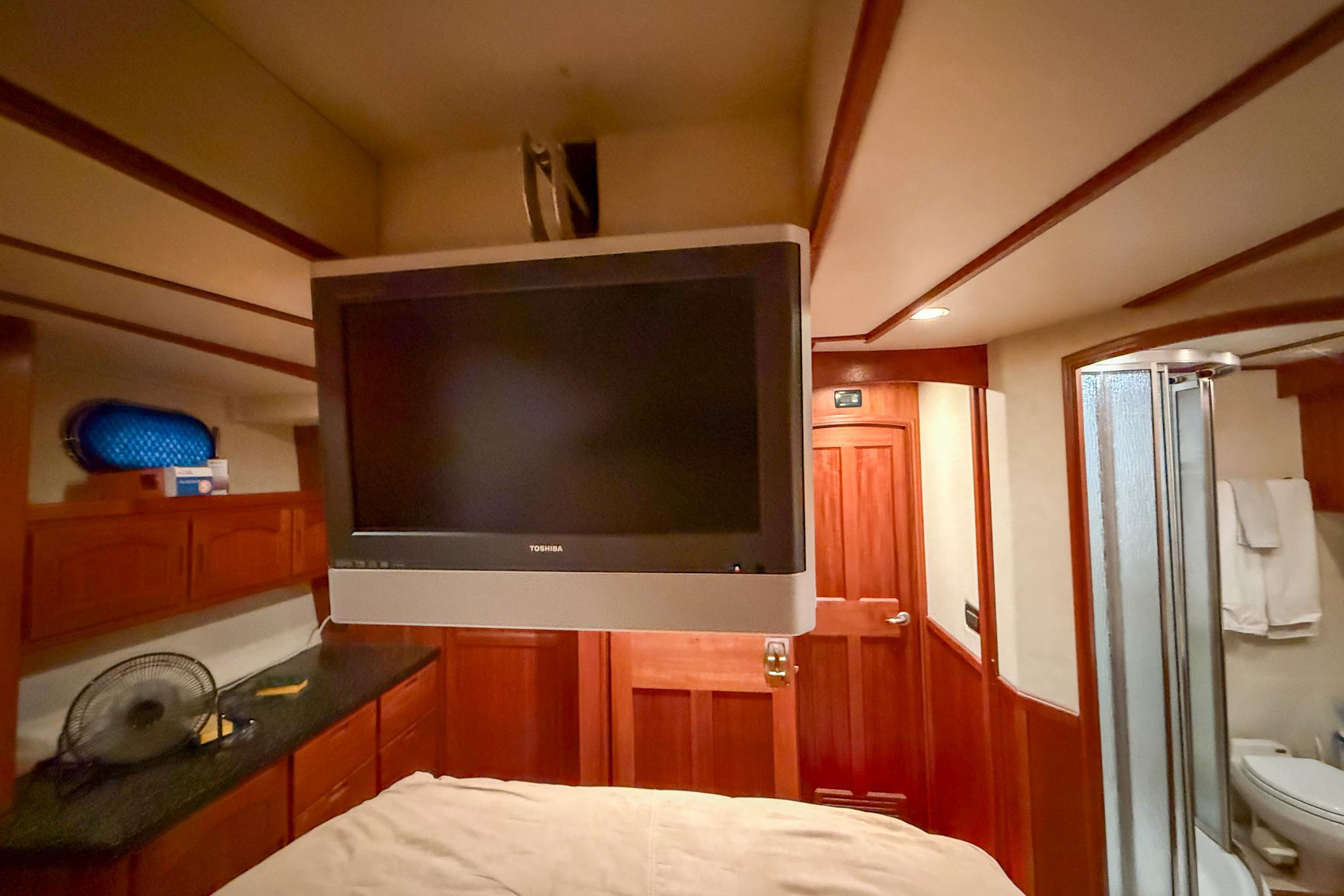 Interior of 2007 Nordic Tug 54 with TV, wooden cabinetry, and bathroom.