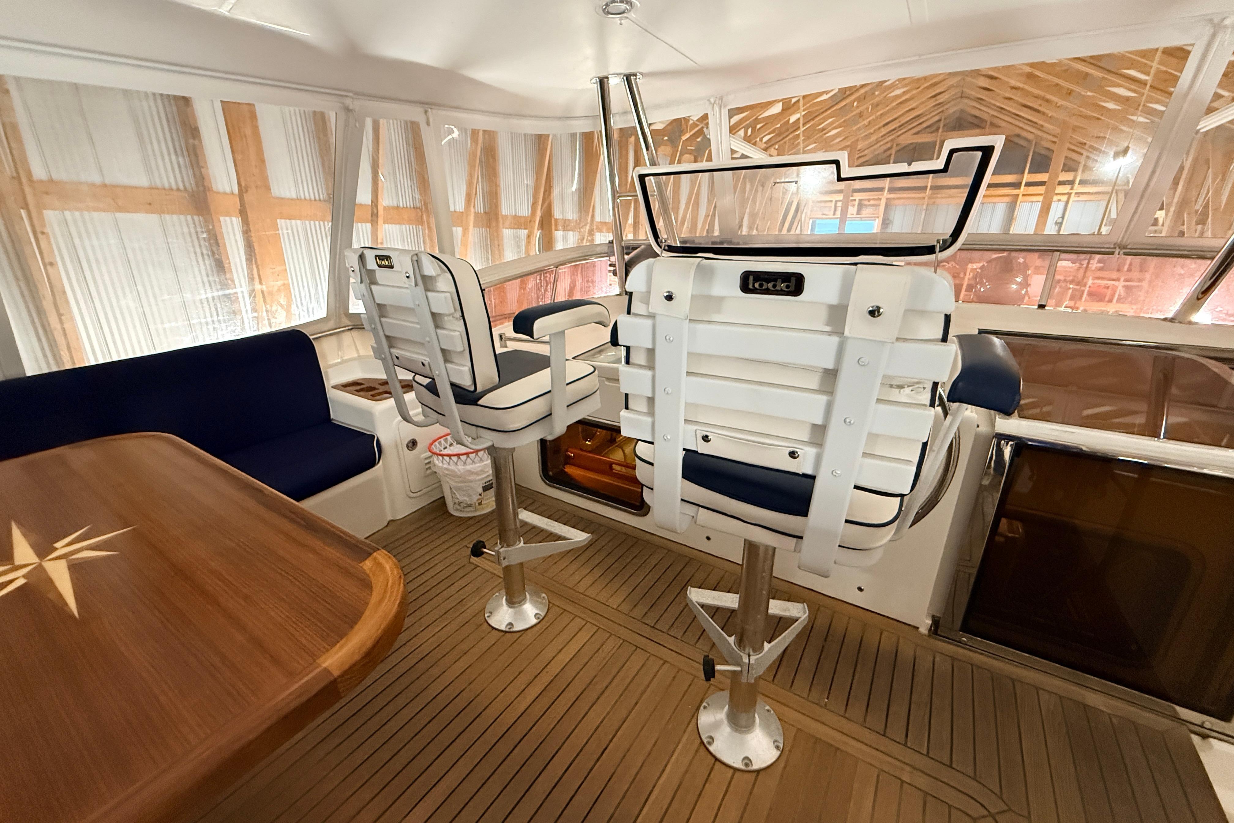 Interior of 2006 Selene 57 yacht with helm chairs and wooden table.