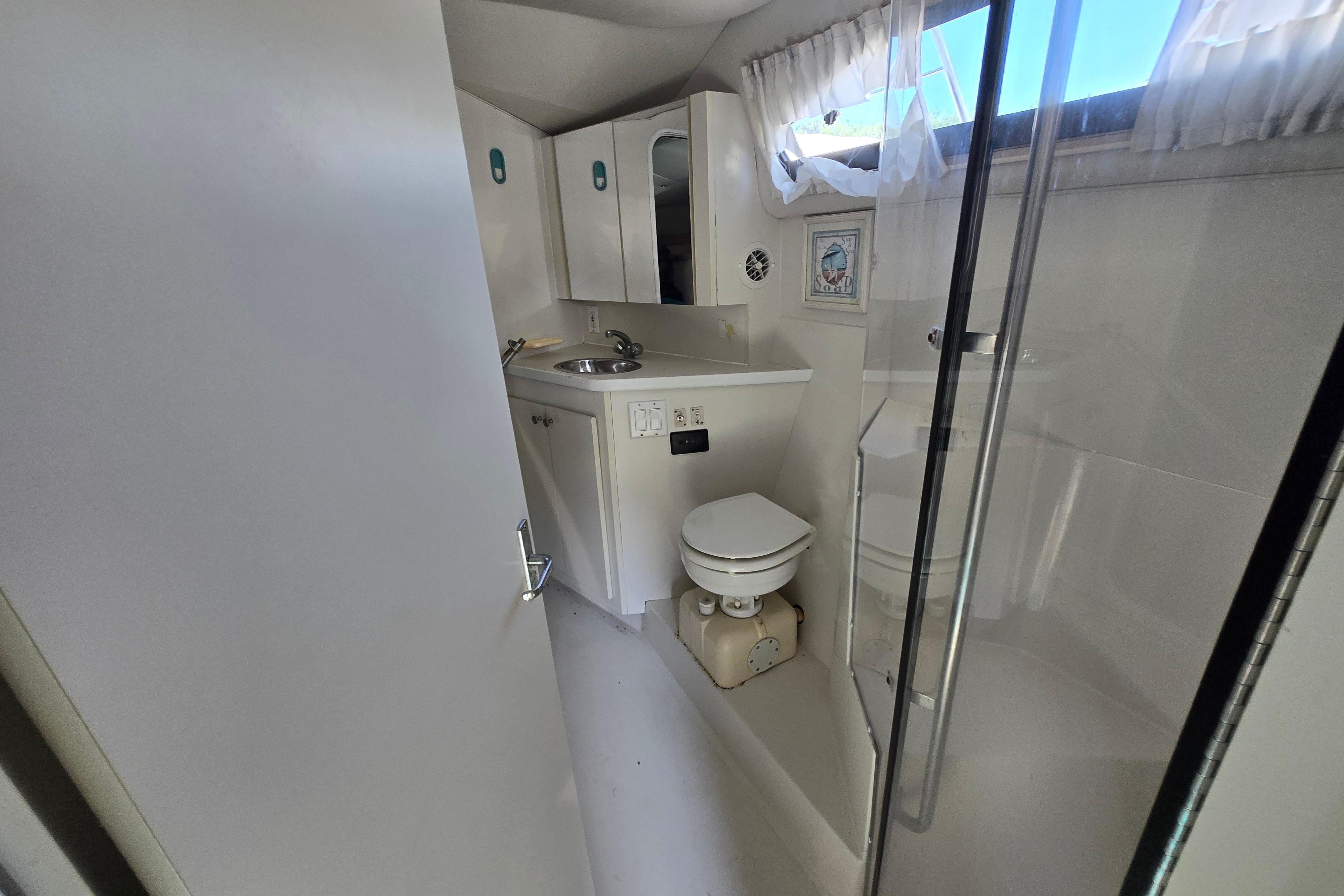 Bathroom interior of 1994 Carver 380 Santego yacht with sink, toilet, and shower.