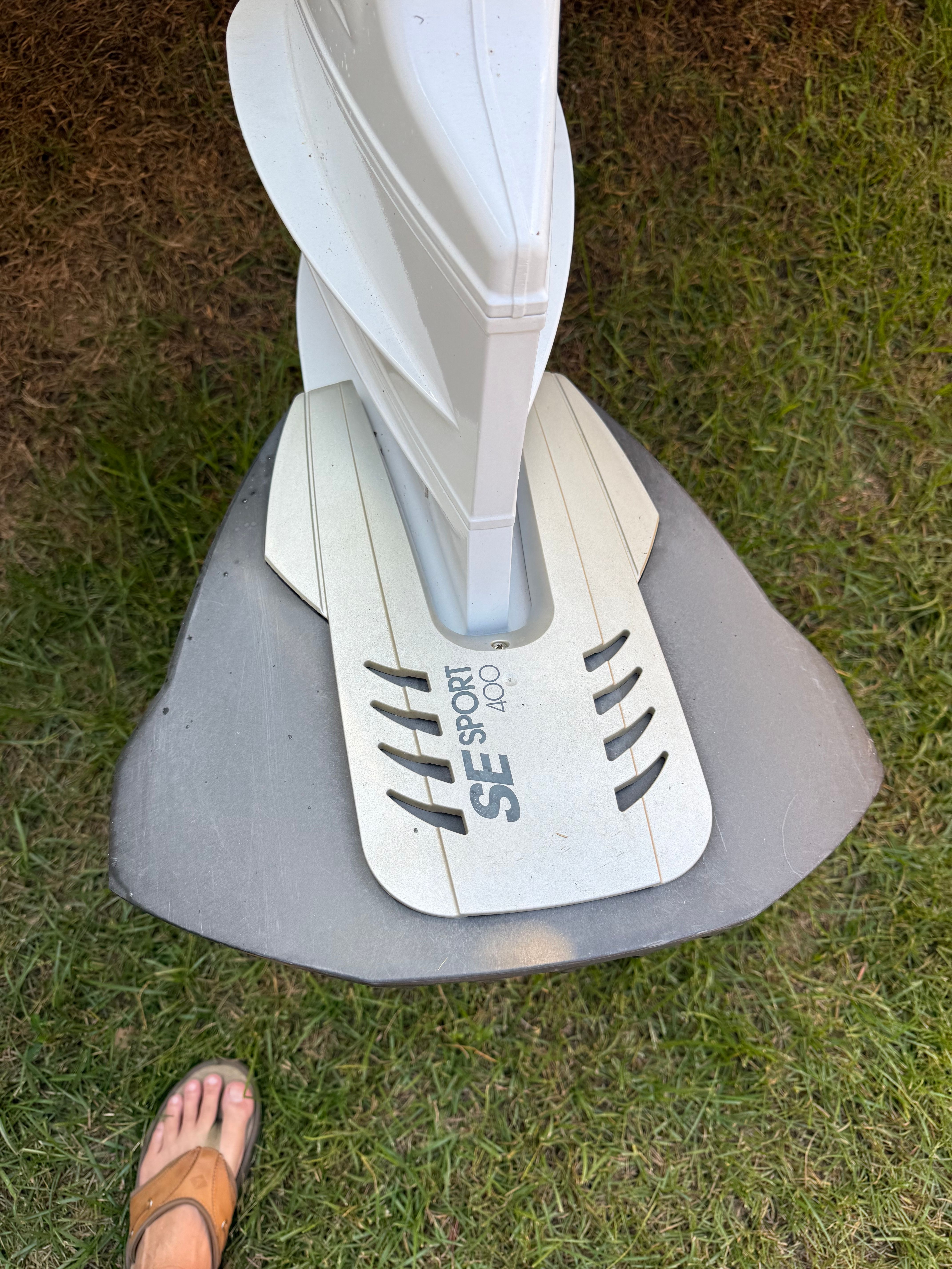 A boat rudder with an SE Sport hydrofoil on grass.
