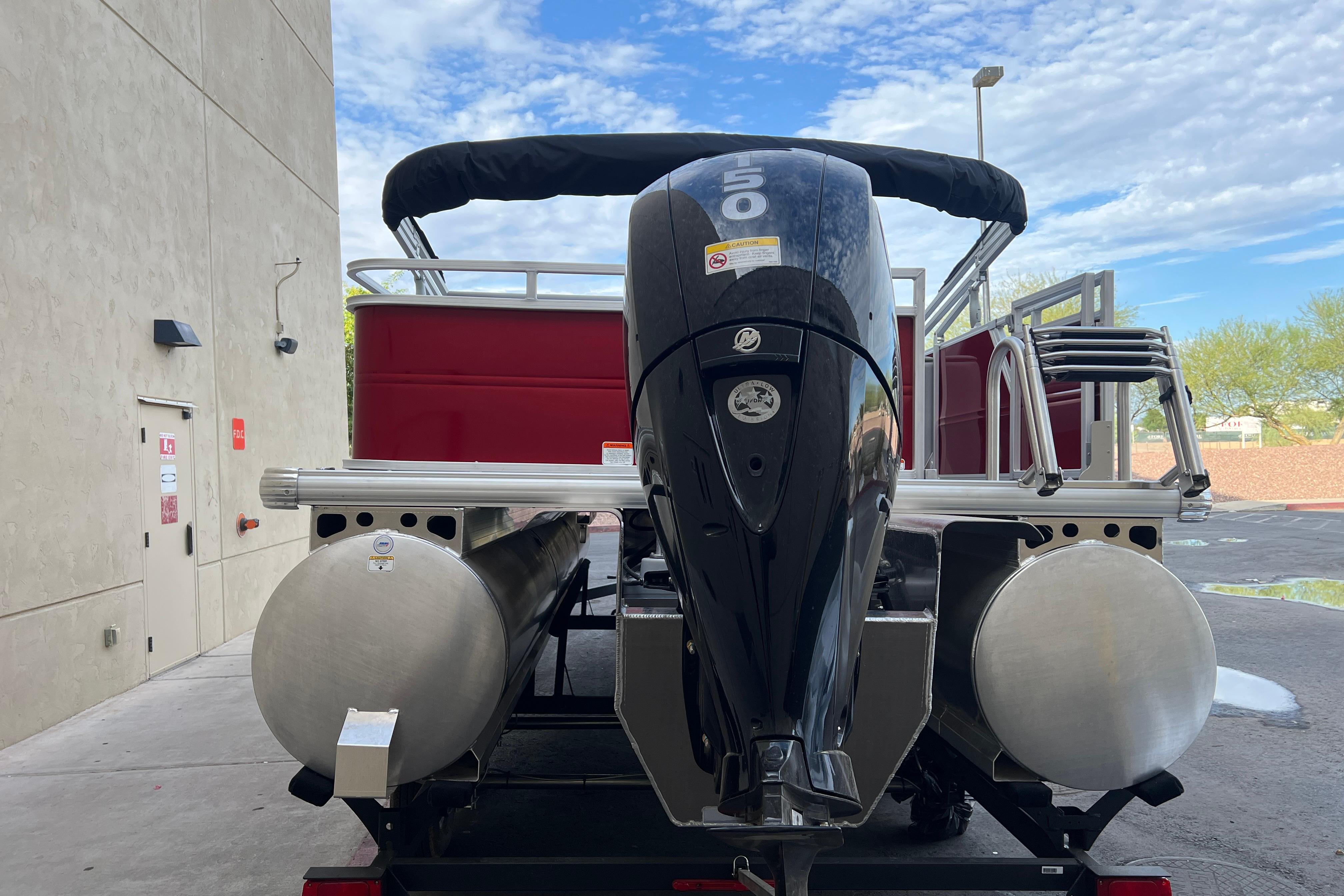 2026 Sun Tracker Party Barge 22 RF XP3 with powerful outboard motor, parked outdoors.