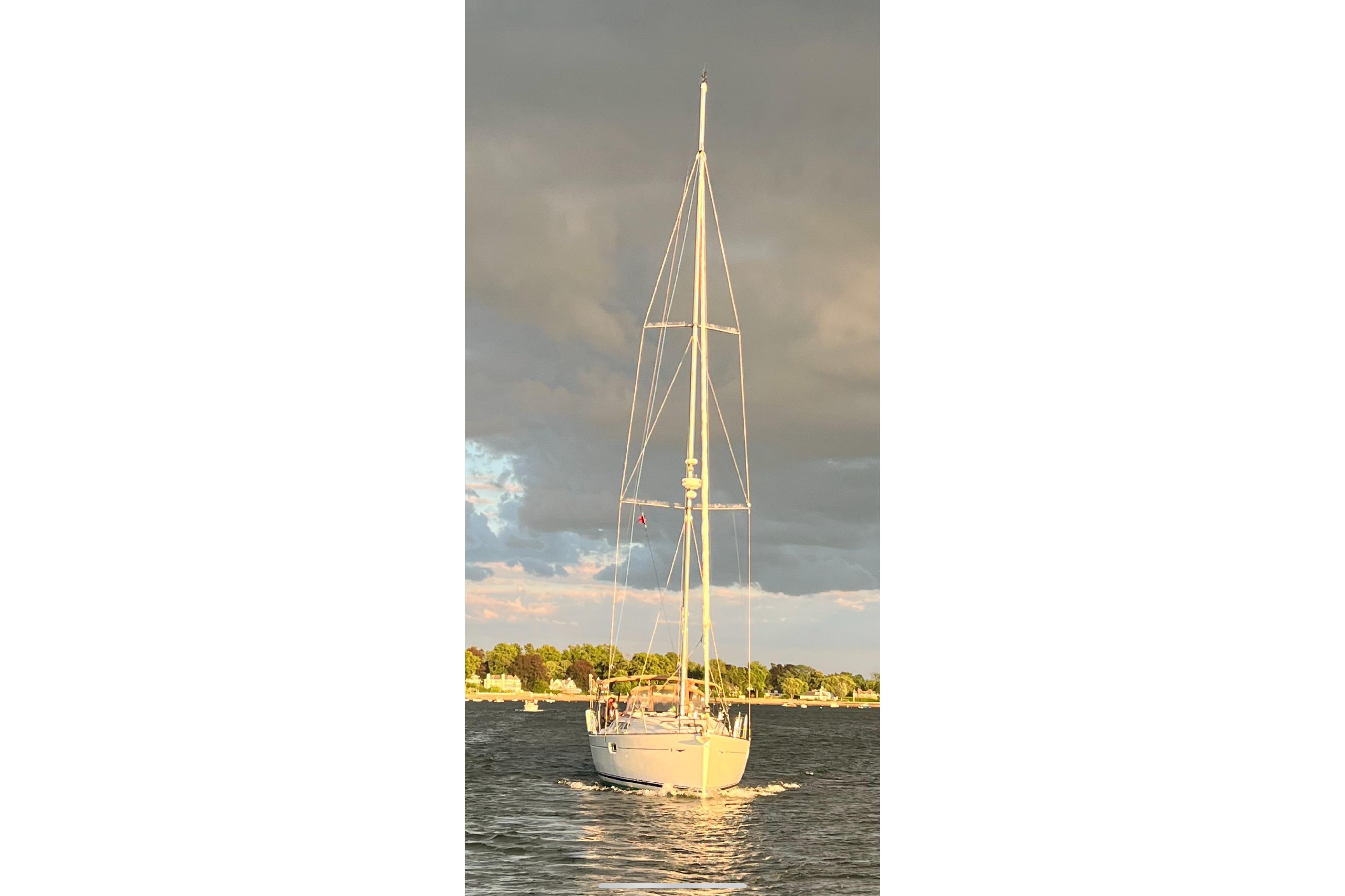 2007 Jeanneau Sun Odyssey 42i sailing on a calm waterway under cloudy skies.