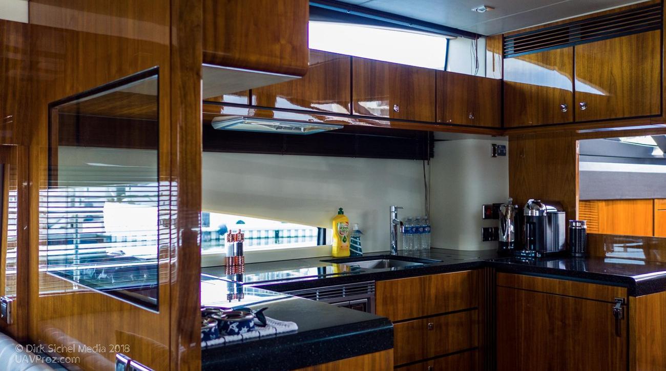 Luxurious kitchen interior of 2012 Fairline Squadron 65 yacht with wooden cabinetry and modern appliances.