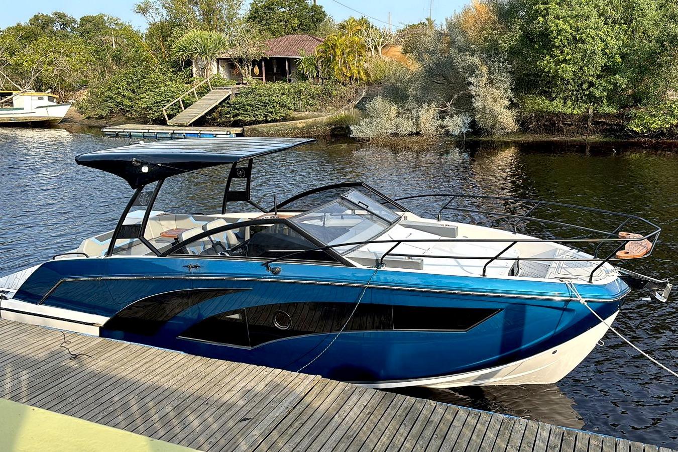 Modern Hanover 327 boat docked on a serene river, surrounded by lush greenery, 2026 model.