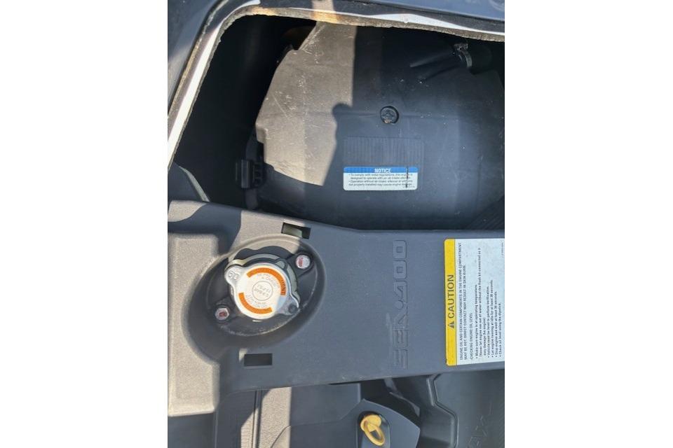 2010 Sea-Doo GTX 155 engine compartment with caution label and cap.