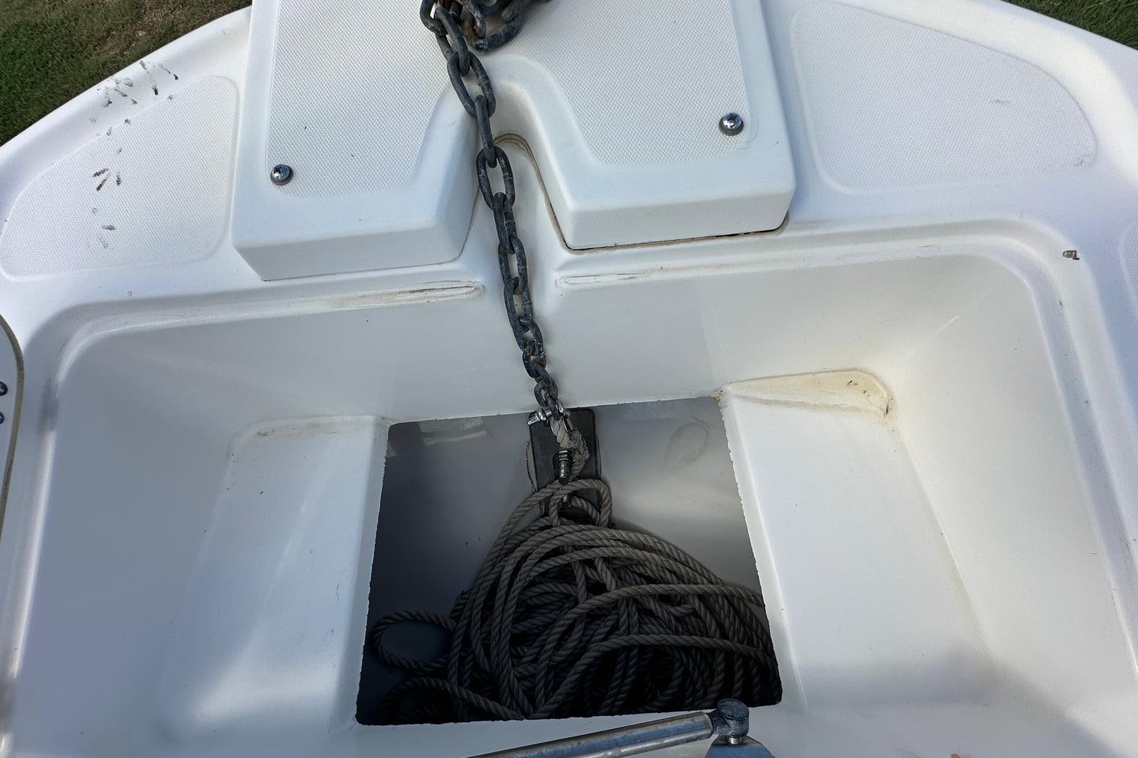 Anchor storage compartment of a 1998 Boston Whaler 23 Conquest boat with chain and rope.