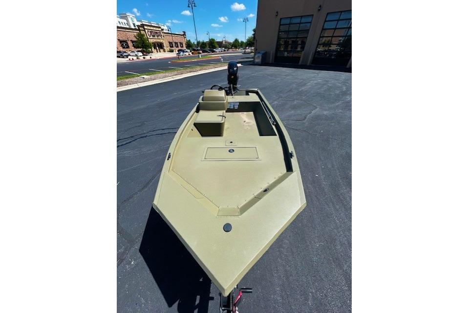 2026 Tracker Grizzly 1648 SC boat in a parking lot under a clear blue sky.