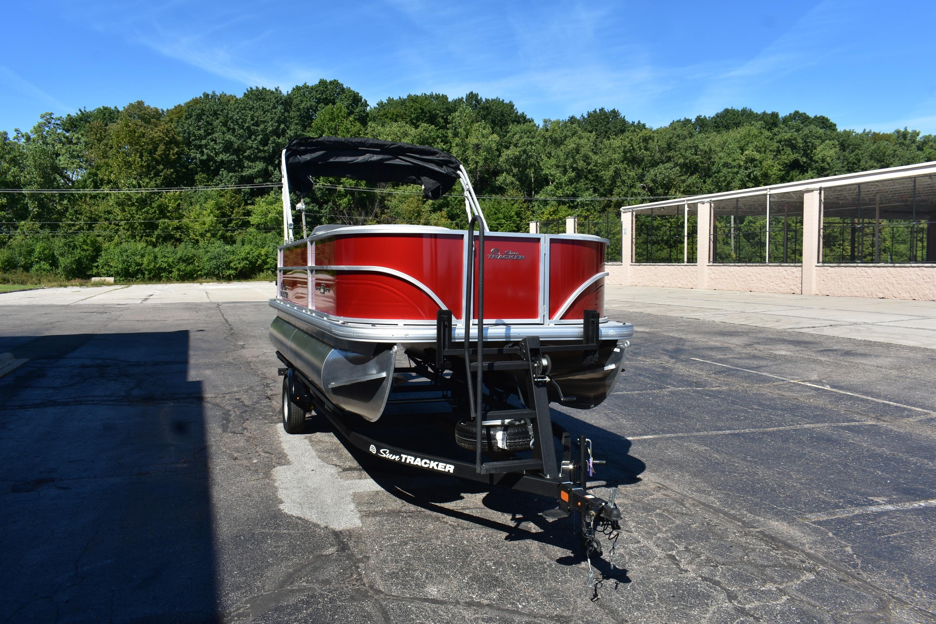 2026 Sun Tracker Party Barge 18 DLX pontoon boat on trailer, parked outdoors.