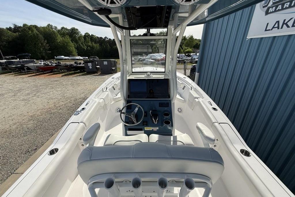 2026 Tidewater 232 LXF boat interior with steering console and seating, parked outdoors.