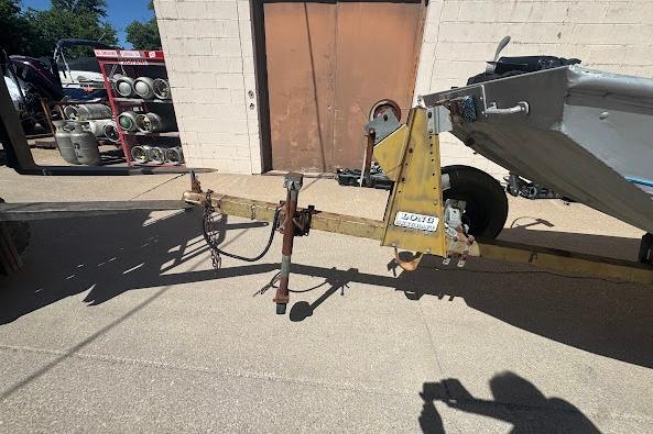 1973 Monark 14 Jon boat trailer parked outside a building.