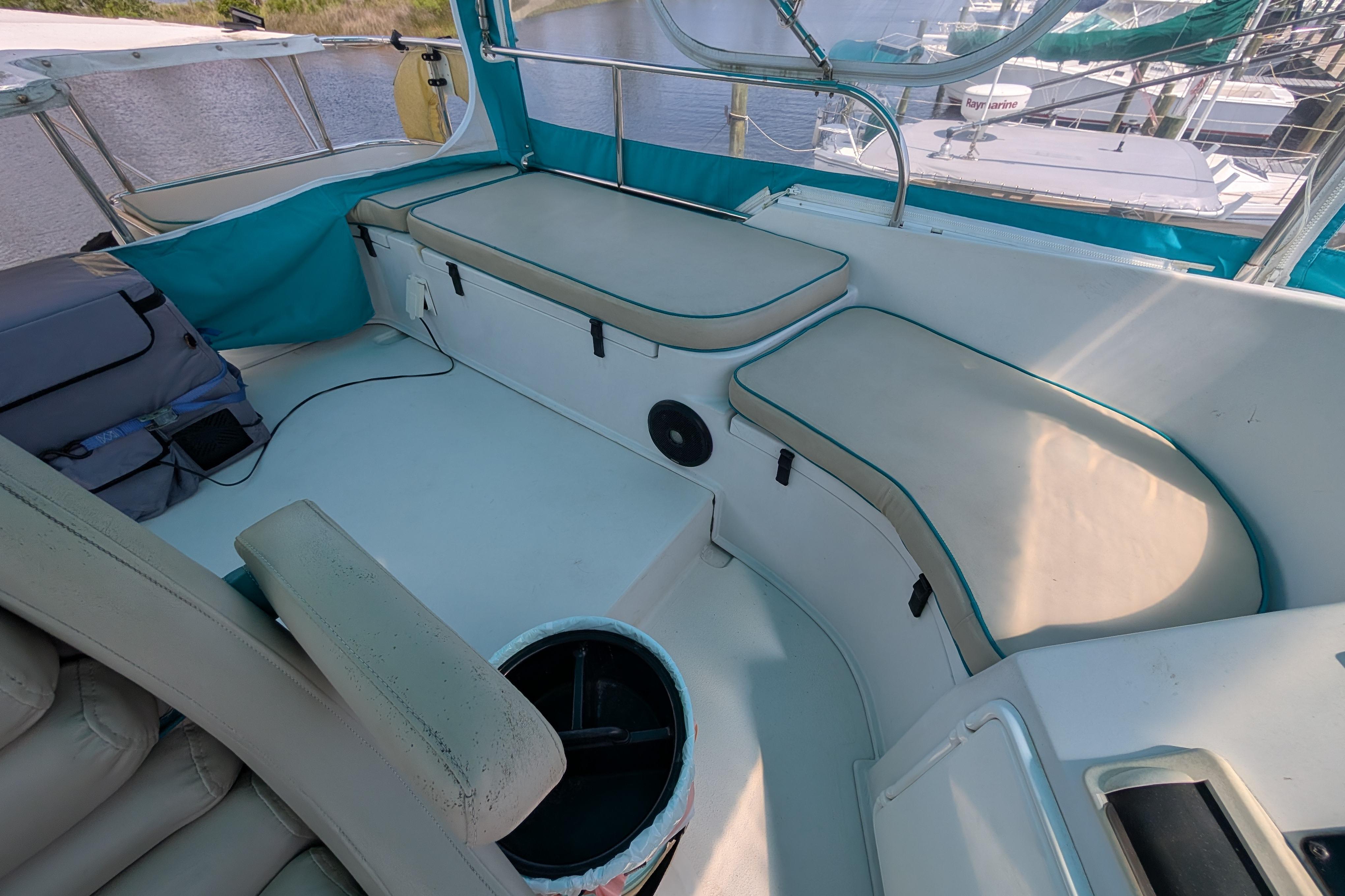 2004 PDQ 34 Powercat boat interior with cushioned seating and teal accents.