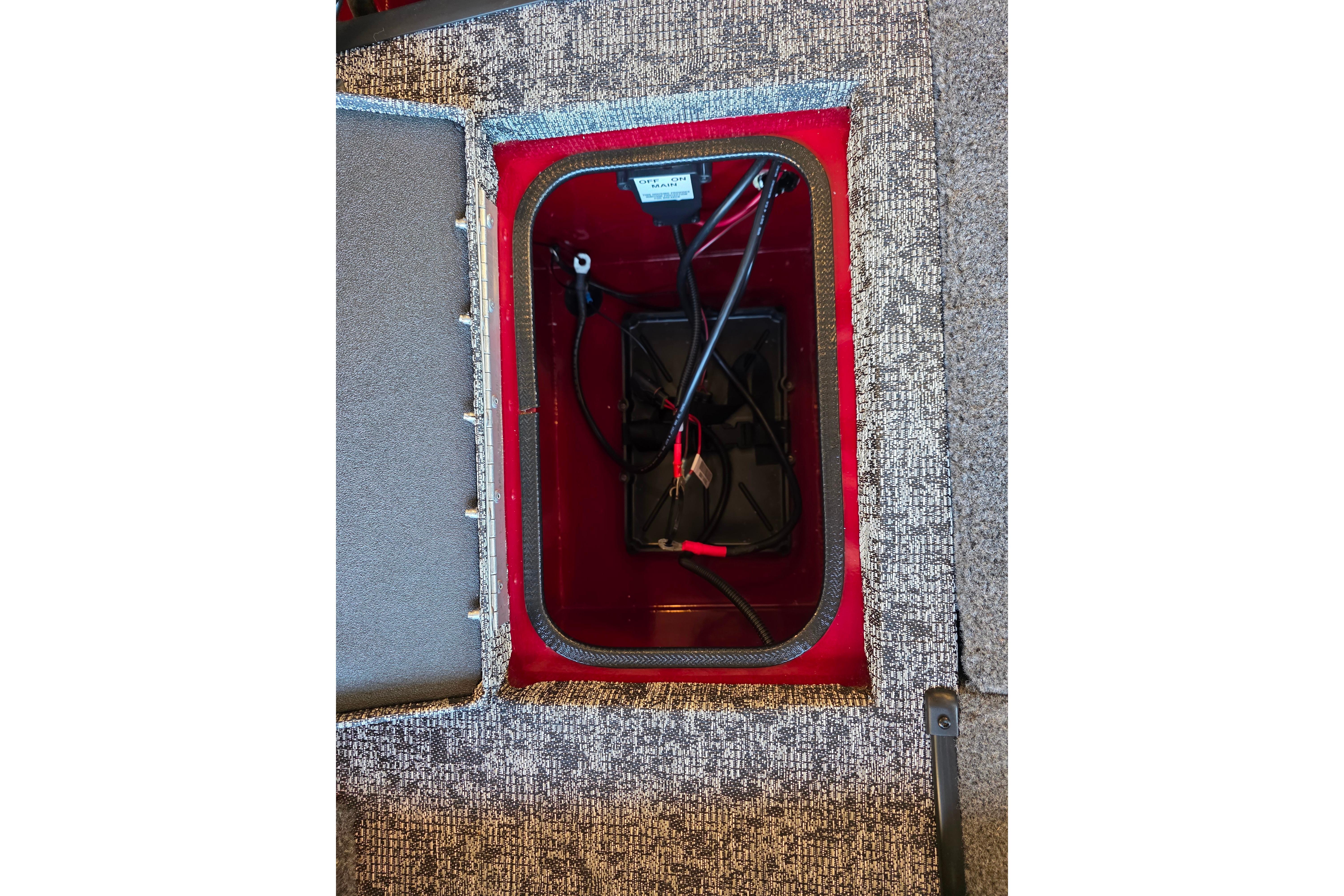 Open storage compartment in 2026 Ranger VS1782SC Reata boat, showing wiring and battery setup.